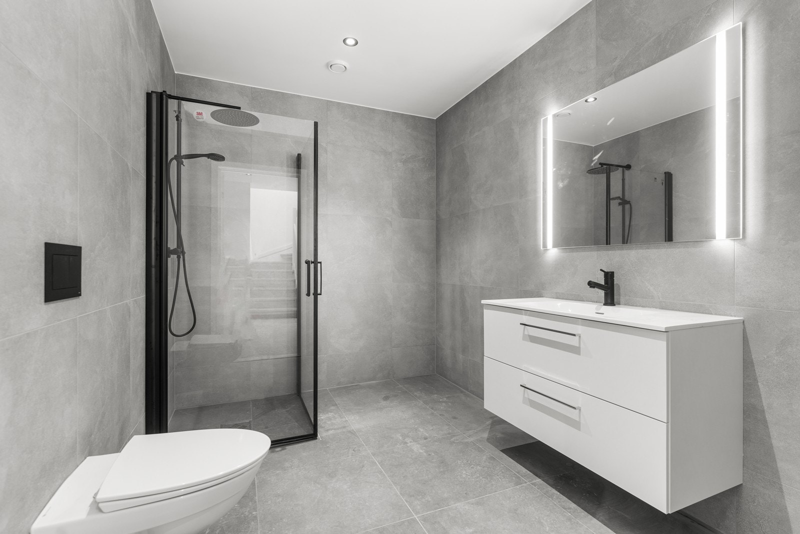 Badet nede har flislagt gulv og vegger med 30x60 fliser og gips med downlights i himling. Galleribilde