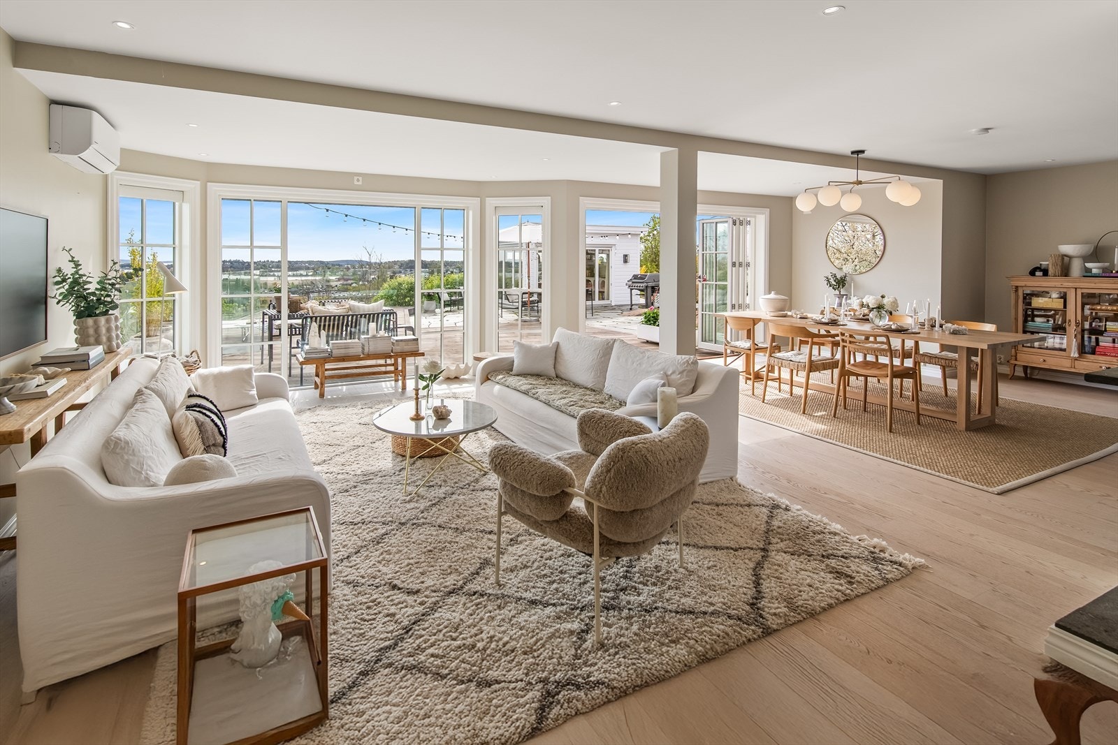 I hovedetasjen finner du en imponerende stue/spisestue med store vindusflater og foldedører som åpner hele fasaden mot øst. Galleribilde