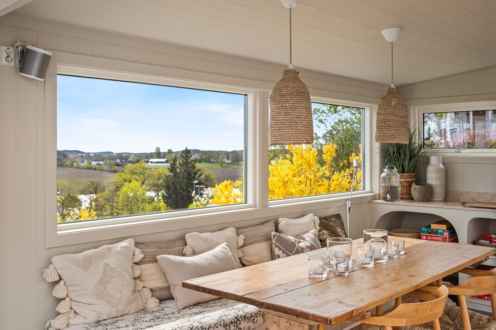 Den isolerte utestuen på 14,9 kvm fremstår som et gjennomført uterom innredet med en langbord og skreddersydd, plassbygget innredning. Galleribilde