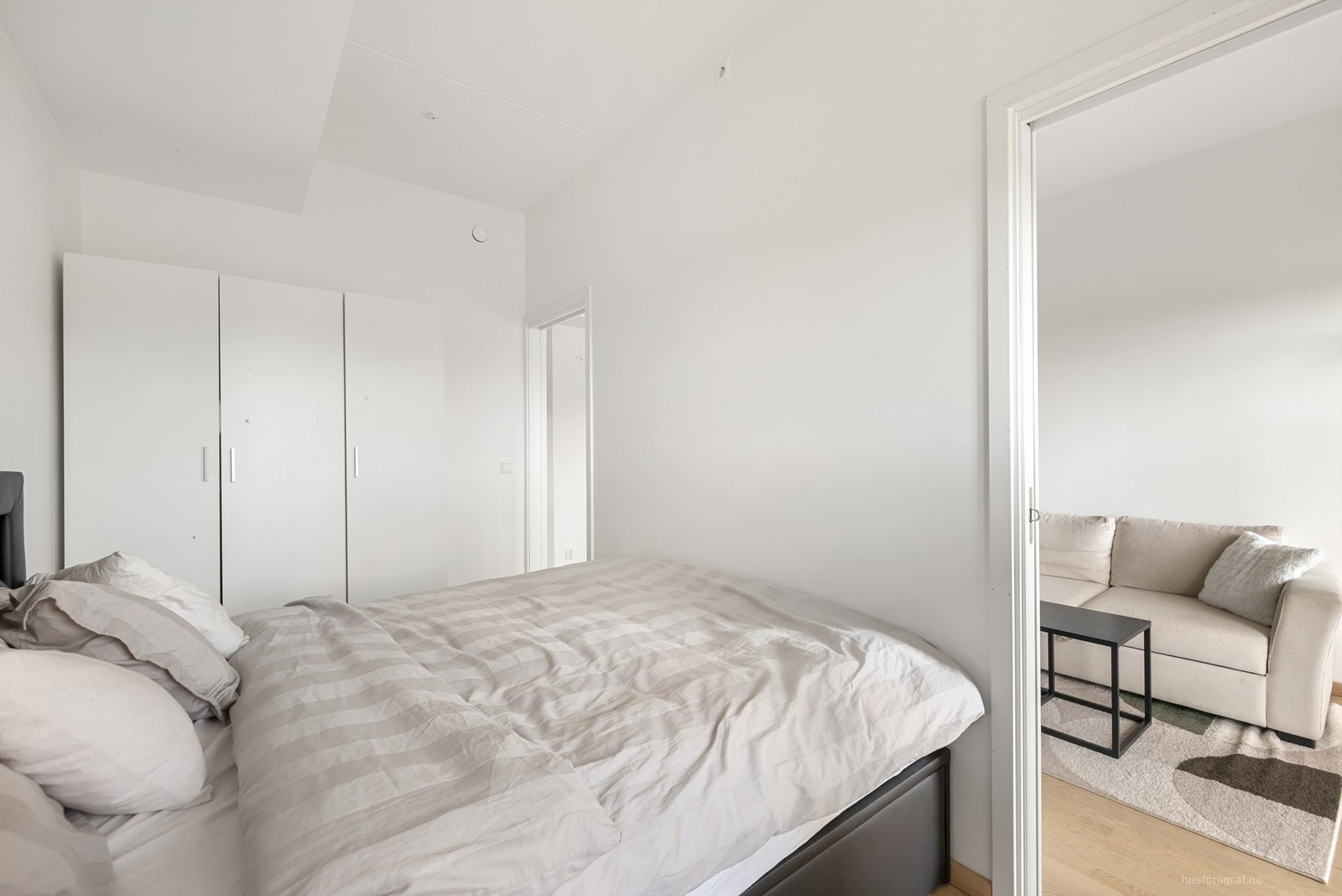 Stort soverom med parkett på gulv og mye lagringsplass Galleribilde