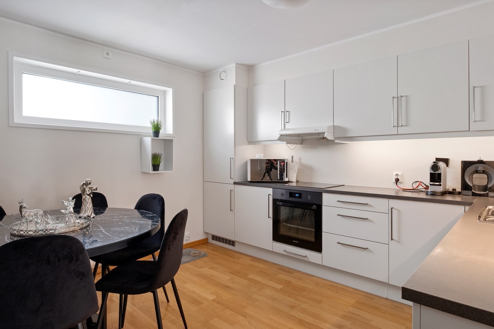 Kjøkkenet har innredning med hvite glatte fronter. Galleribilde