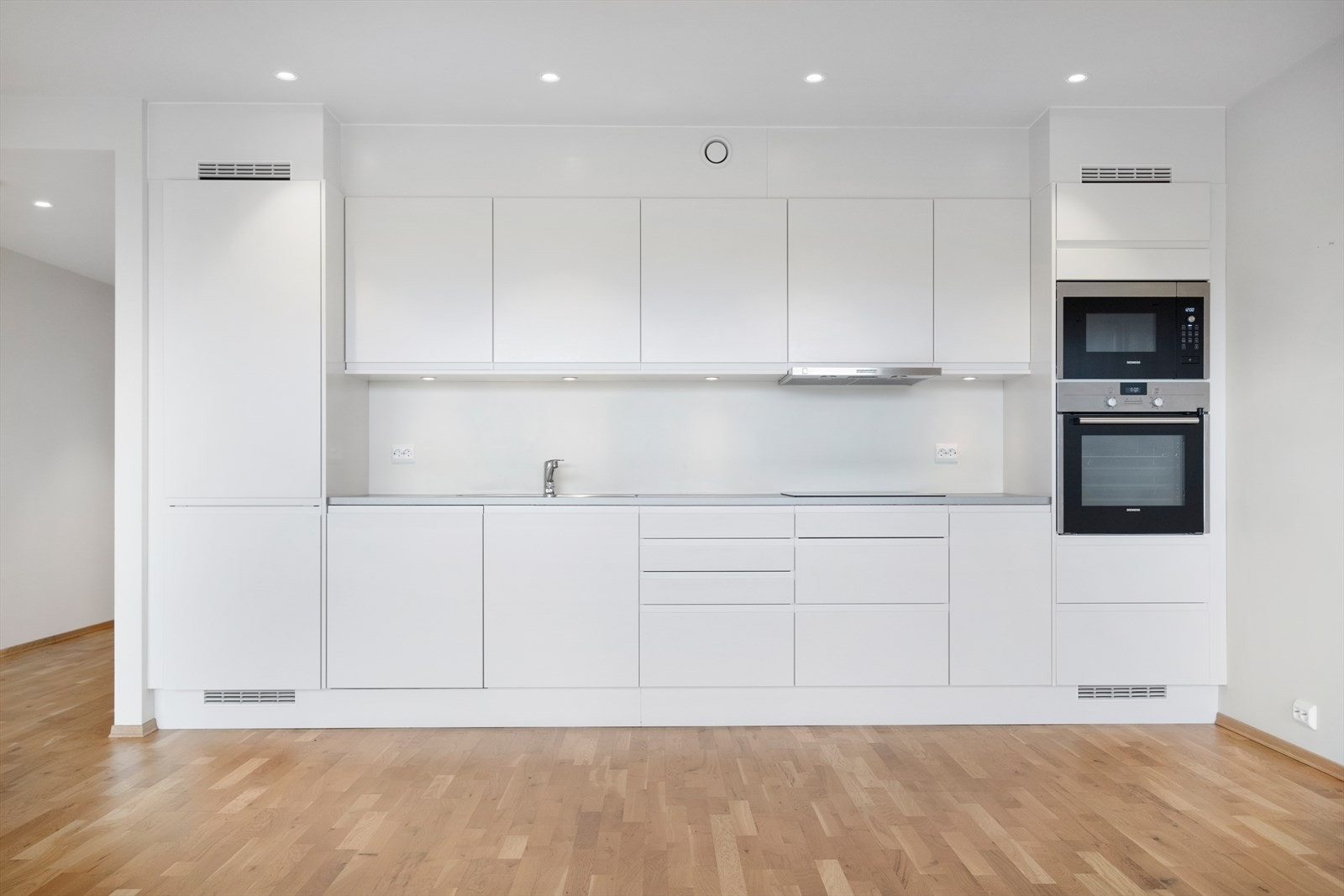 Hvitevarer som kjøleskap, oppvaskmaskin, induksjonstopp, mikro og stekeovn er integrert Galleribilde