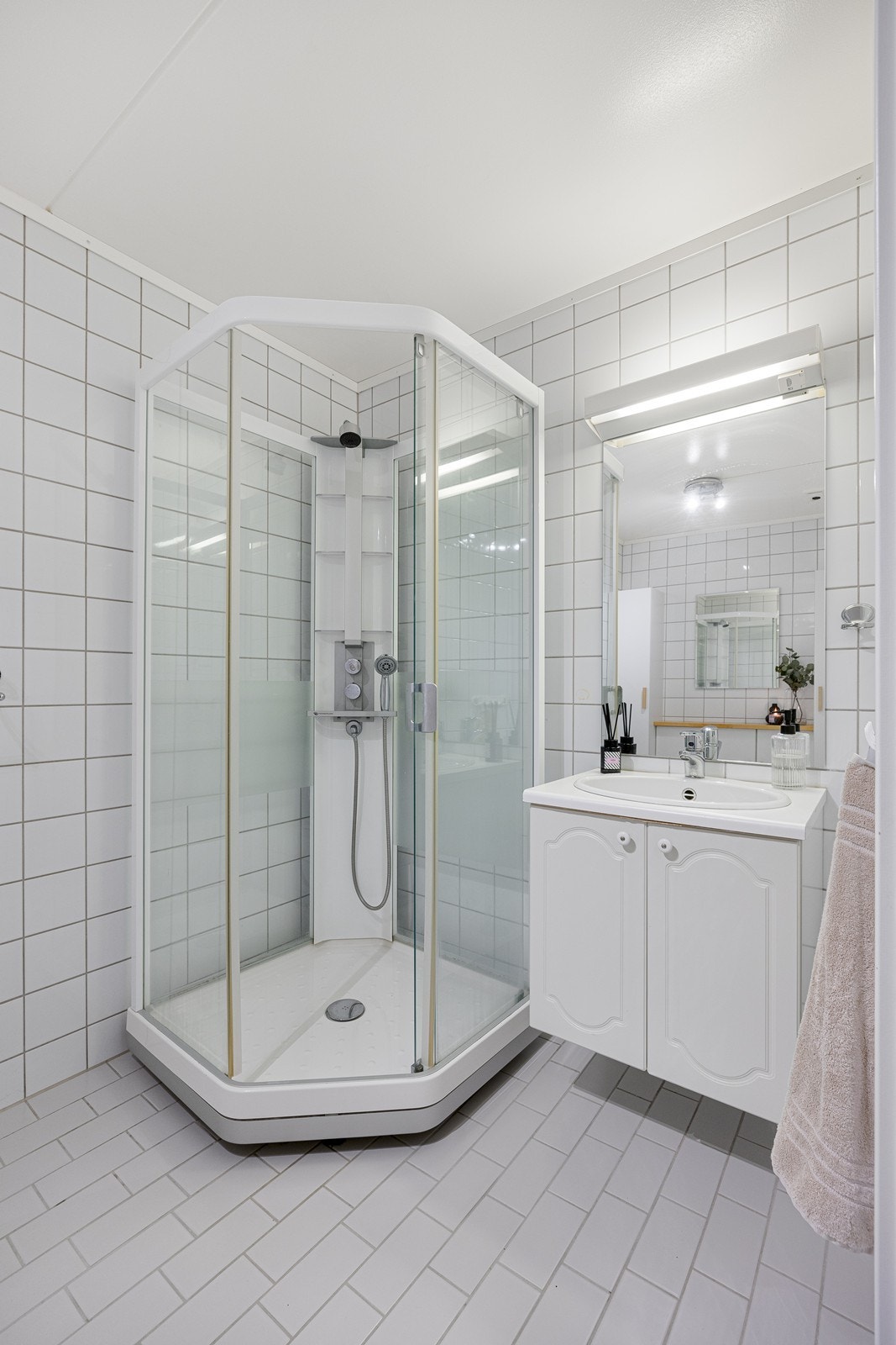 Innredningen består av servant med hvite underskap og et speil med belysning Galleribilde