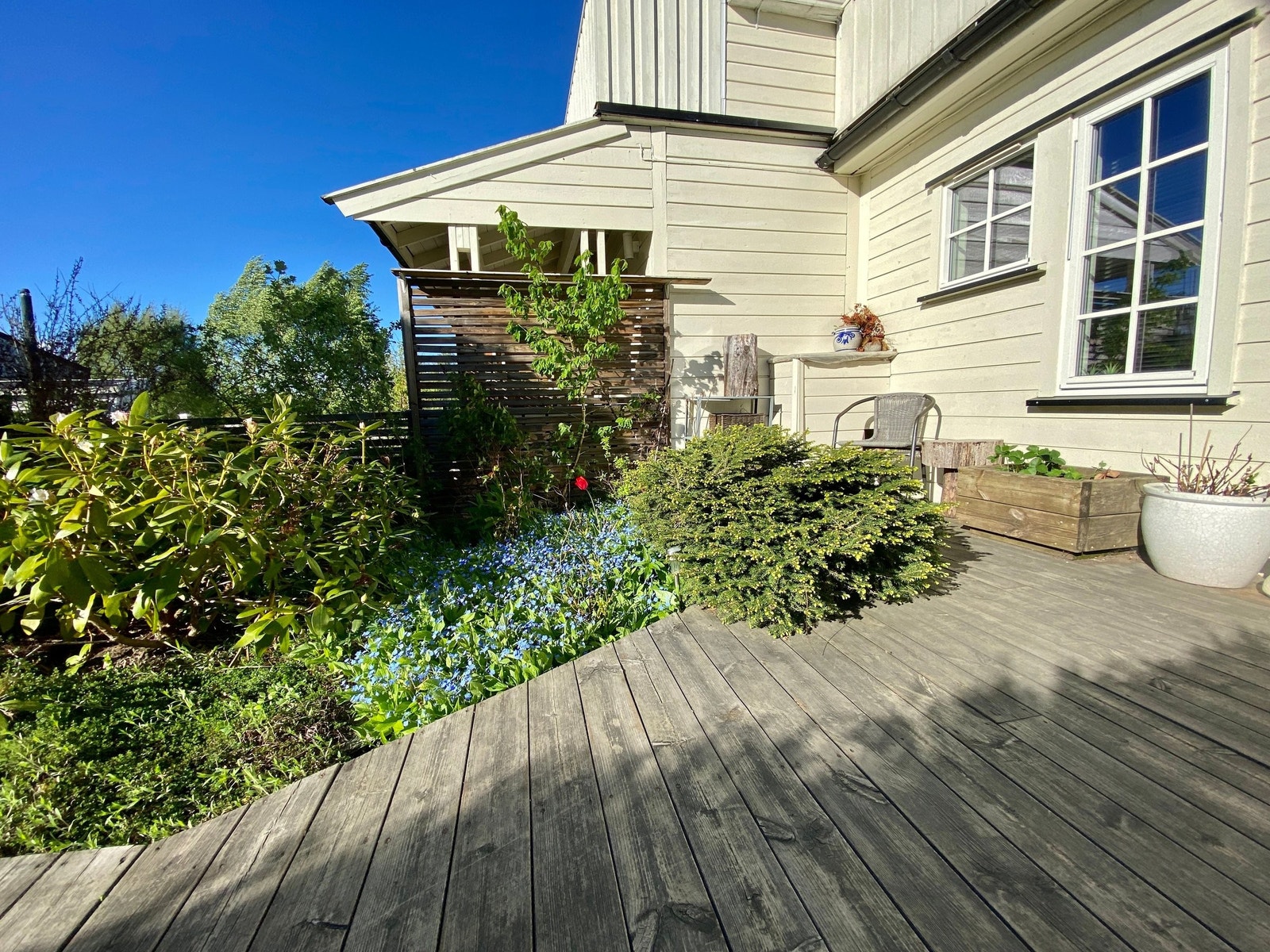 Uteplass 4. Koselig vestvendt inngangsparti og hage med platting, sitteplass og beplantning Galleribilde