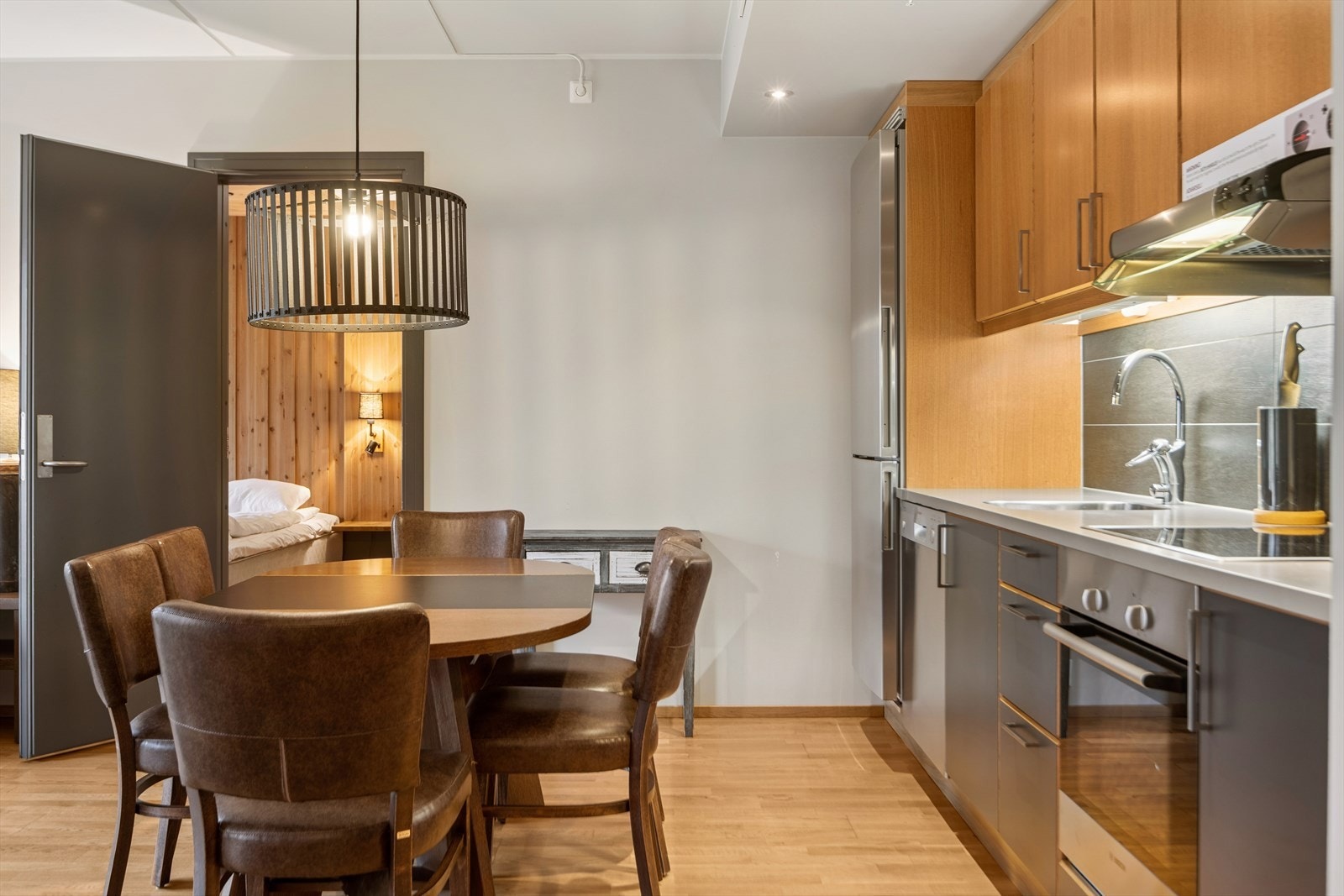 Åpen løsning mellom stuen og kjøkkenet. God plass til spisestue i tilknytning til kjøkkenet. Videre ser du inn til "connecting-room". Galleribilde