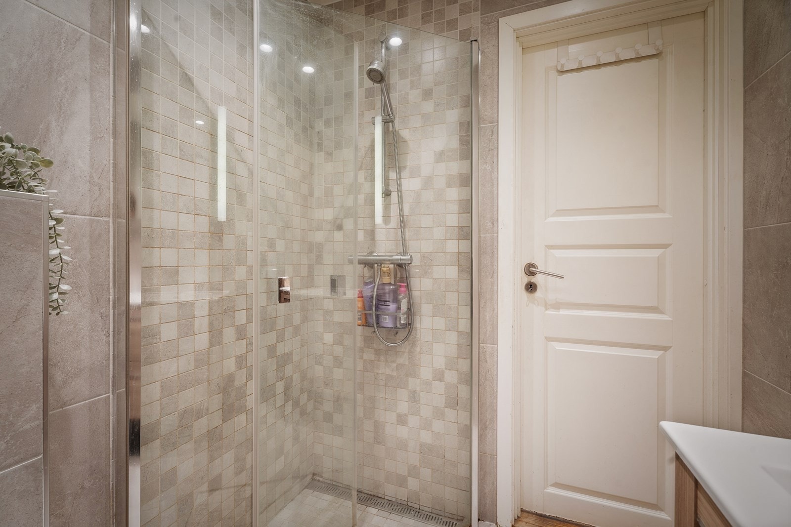 Innredningen består av servantskap, veggengt toalett og dusjhjørne med svingbare glassdører. Galleribilde