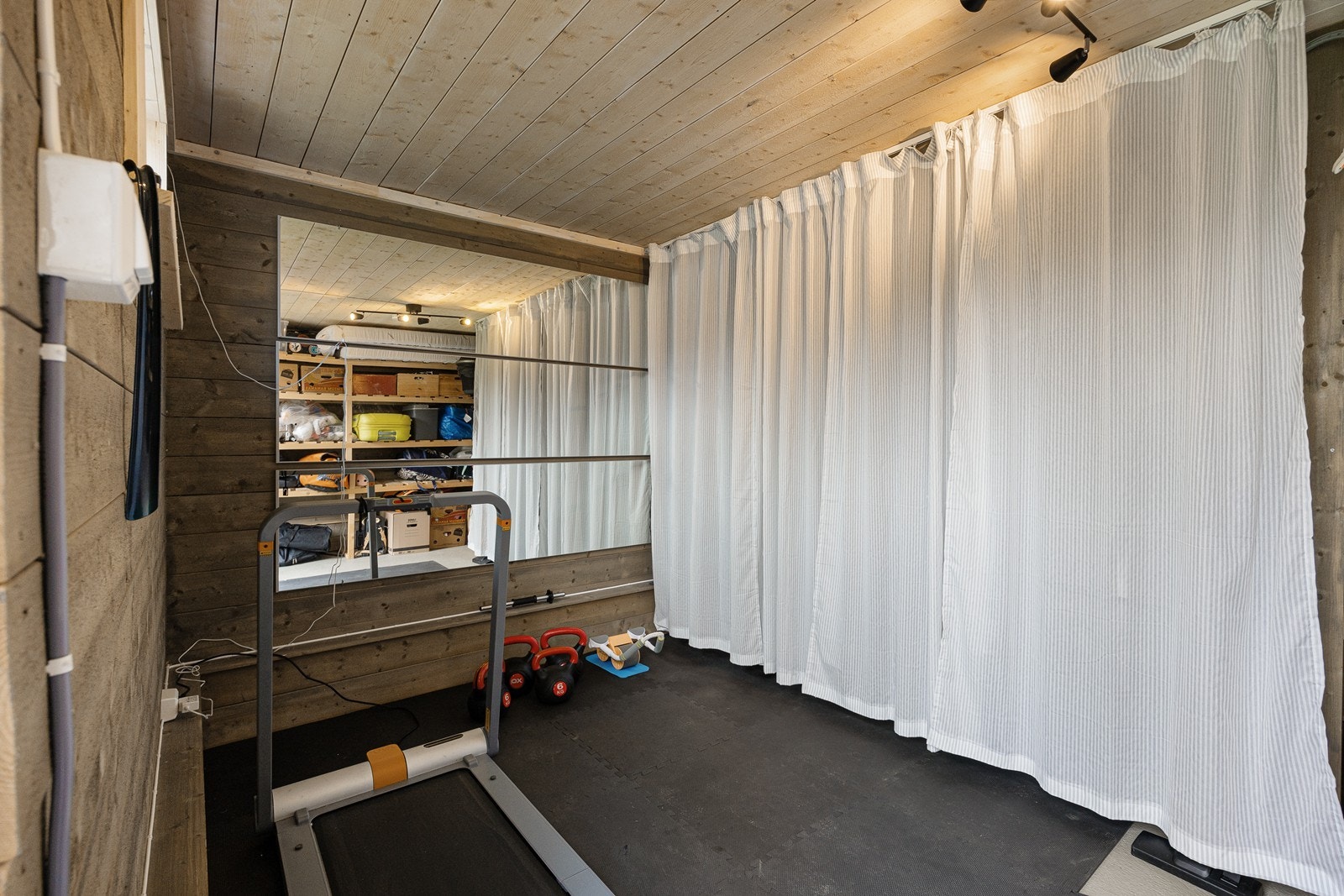 Den frittstående uteboden har nåværende eier innredet som et treningsrom Galleribilde