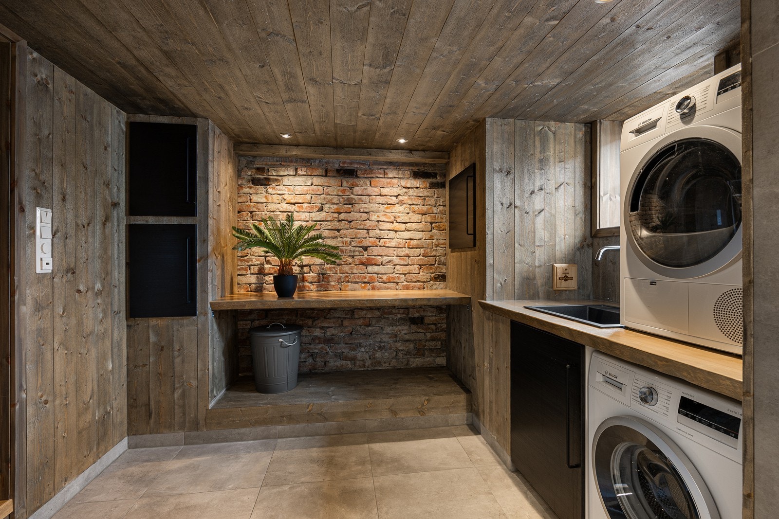 Det er også en teglsteinsvegg og spesialbygd vaskeromsinnredning av tre, noe som gir en ekstra rustikk og spesiell romfølelse Galleribilde