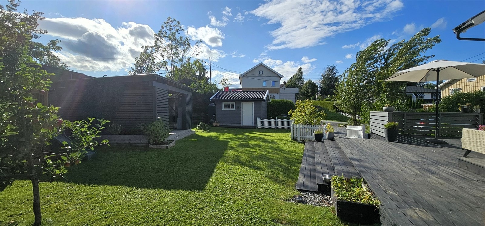 Hagen er pent opparbeidet med bl.a. plen, terrasser, hagestue/pergola og frittstående utebod Galleribilde