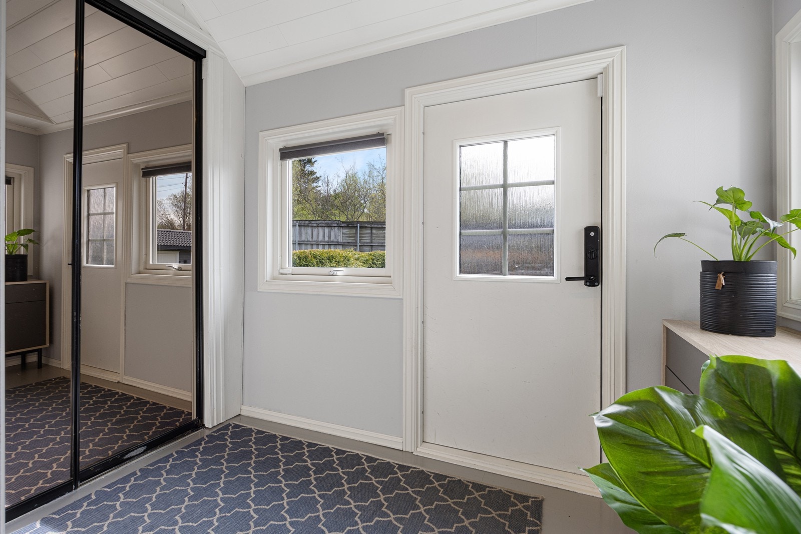 Entreen har malt furugulv, lysmalte vegger og god plass til kommode, skohylle eller lignende. Rommet har også skyvedørsgarderobe med speilfronter Galleribilde