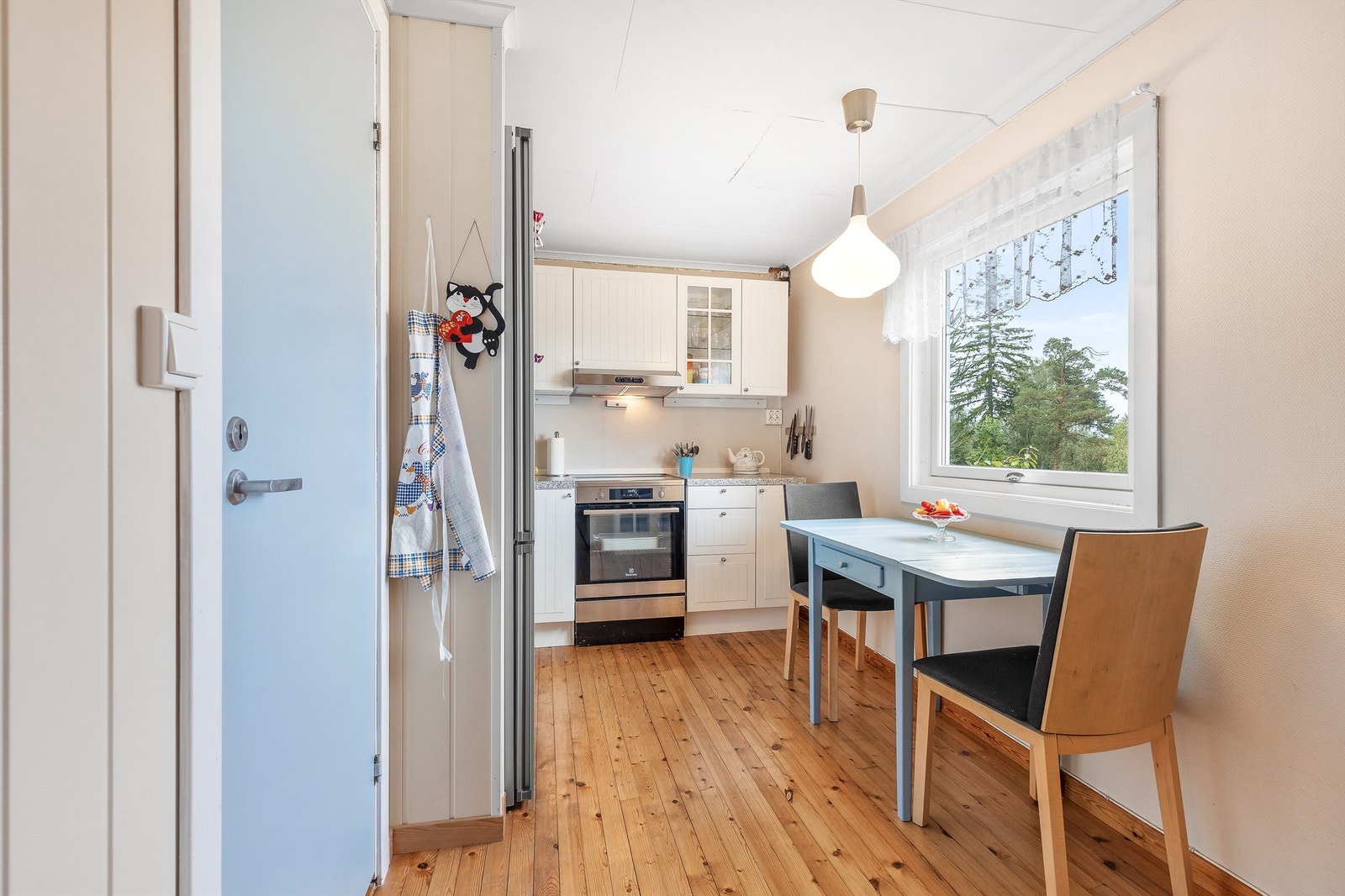 Profilert kjøkkeninnredning med over- og underskap samt vitrineskap i hvit utførelse Galleribilde