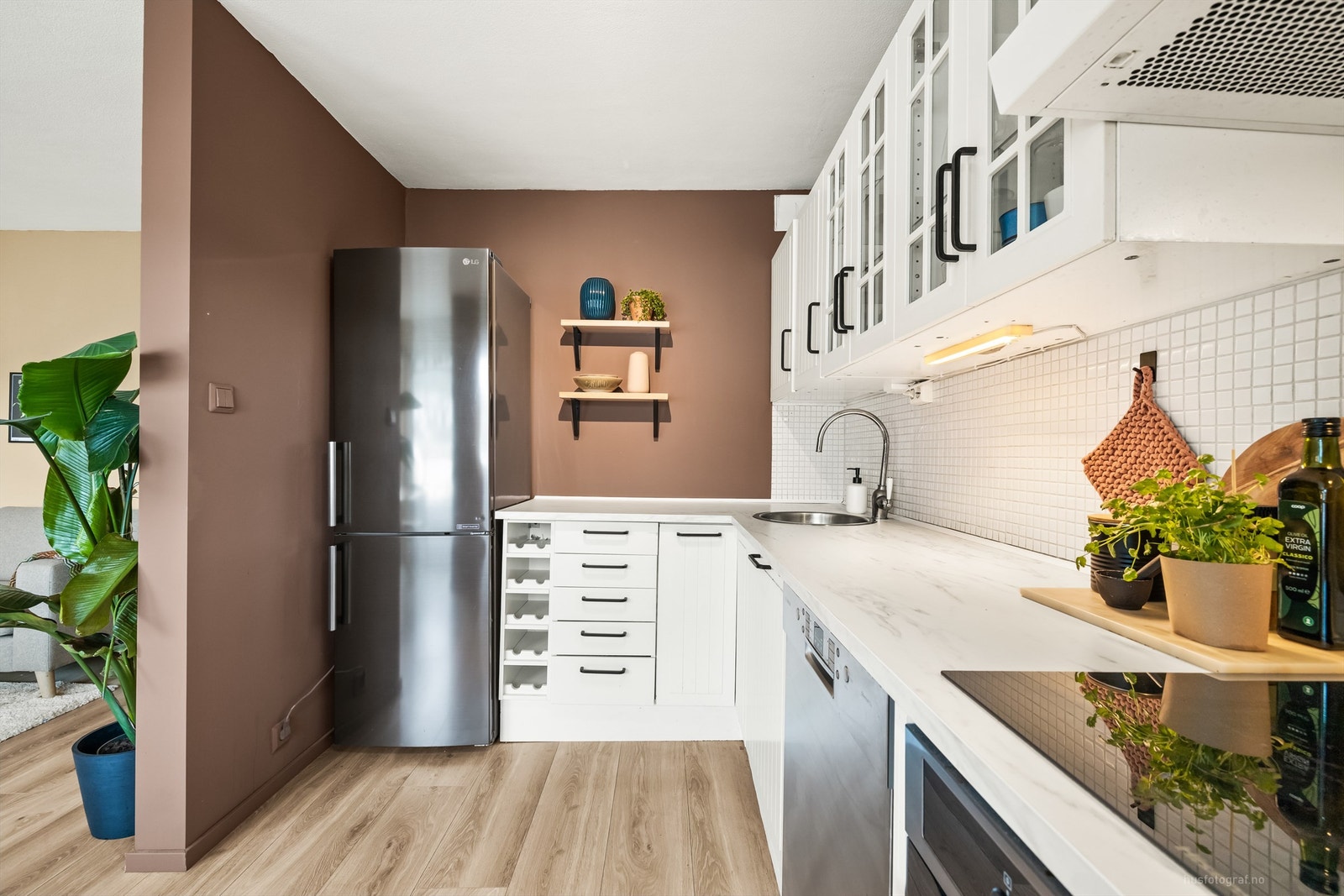 Laminat på gulv, malte veggflater og malte himligsflater. Fliser på vegg mellom kjøkkenbenk og overskap. Galleribilde