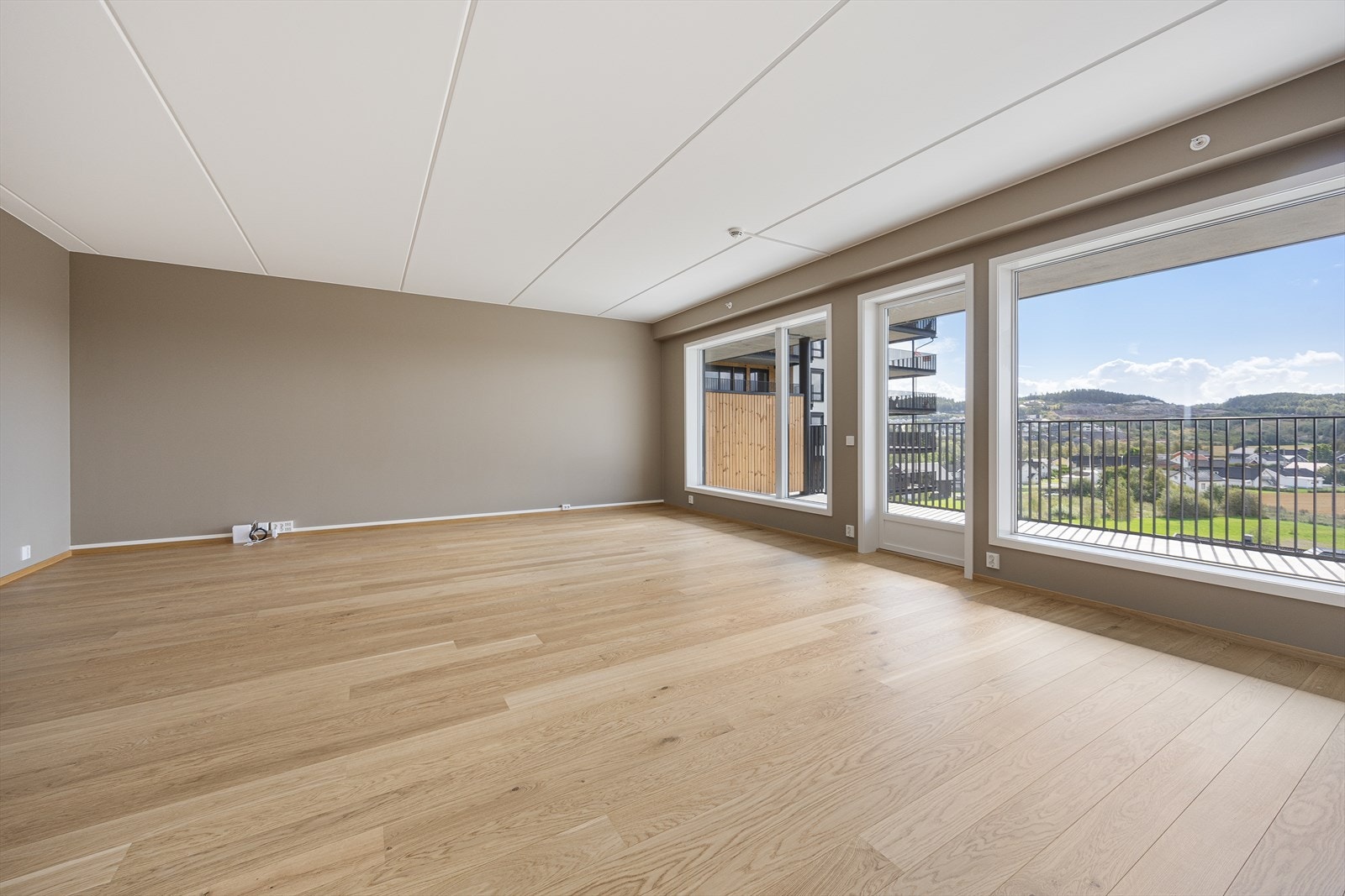 Rommet har pent parkettgulv, glatte vegger malt i en lun gråfarge og listefri overgang til hvitmalt himling Galleribilde