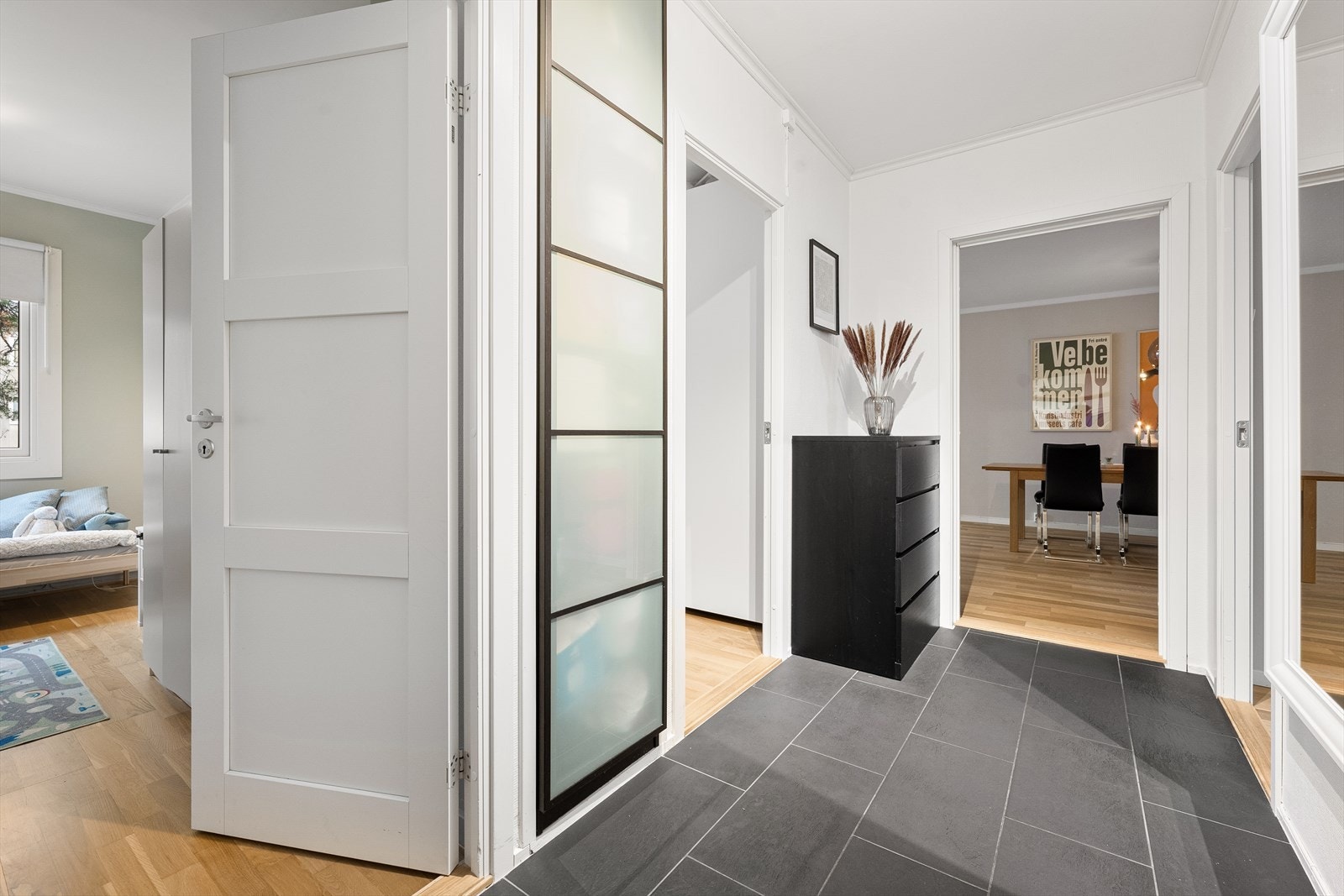 Lys og romslig entré med flislagt gulv og god plass til garderobeløsning og oppbevaring Galleribilde