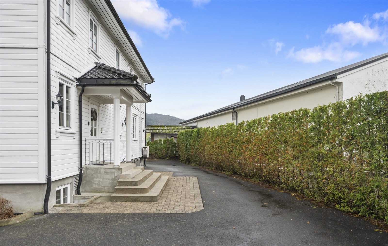 Husets inngangsparti er pent opparbeidet med steinlagt gangvei og trapp. Galleribilde