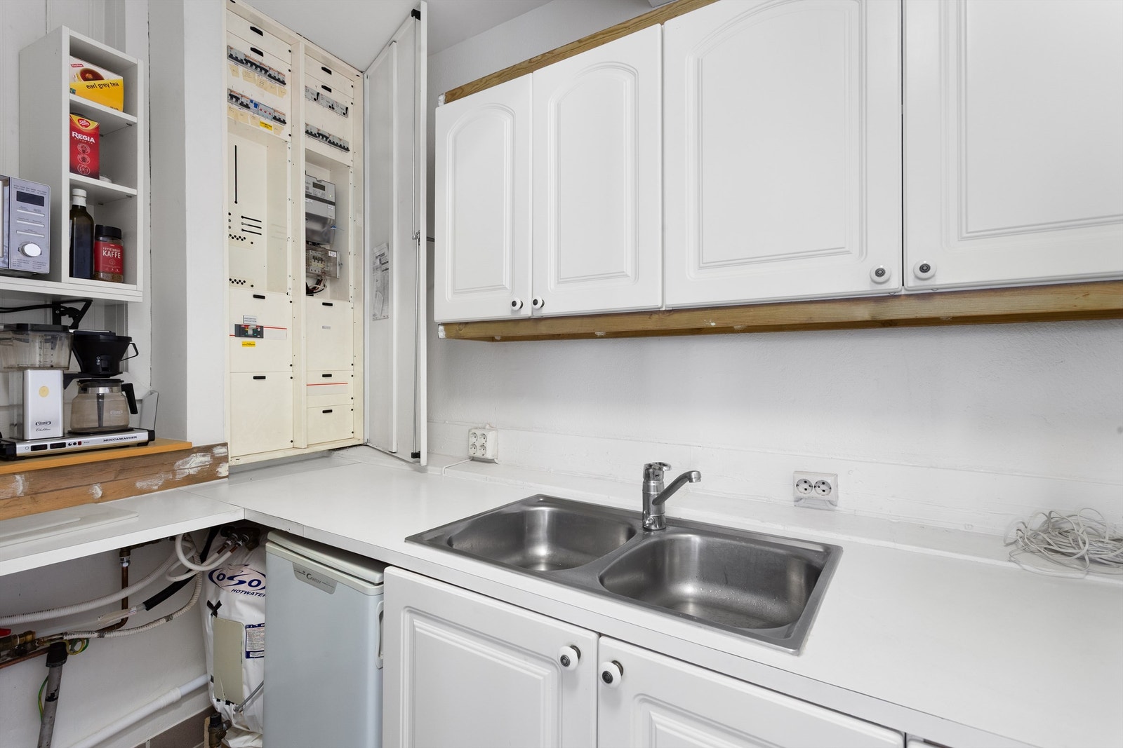 Profilert kjøkkeninnredning med over- og underskap i hvit utførelse Galleribilde