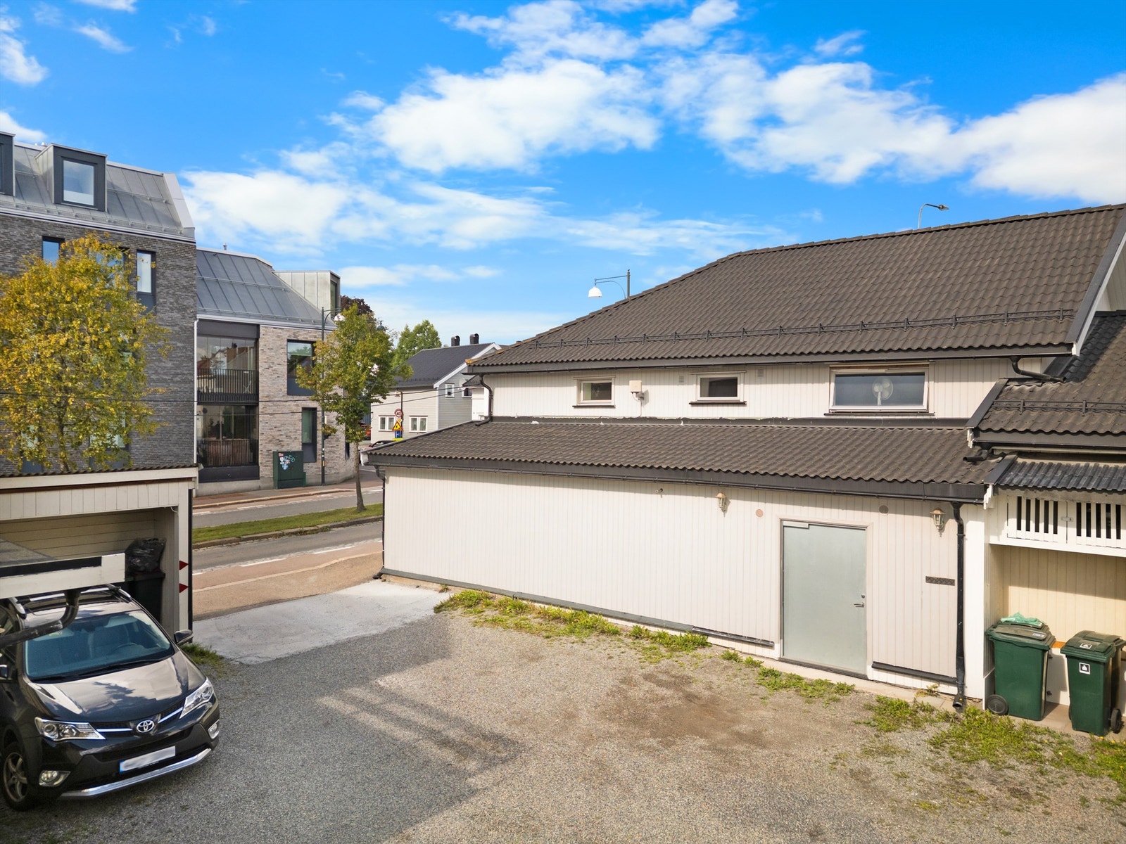 Parkering i gruset og delvis støpt bakgård Galleribilde