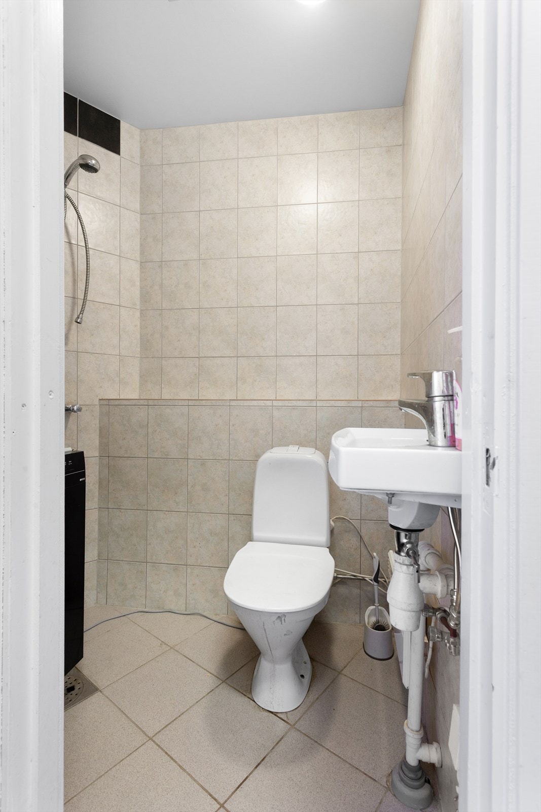 Wc-rom med vegghengt servant, gulvstående toalett og veggmontert dusjarmatur (frakoblet) Galleribilde