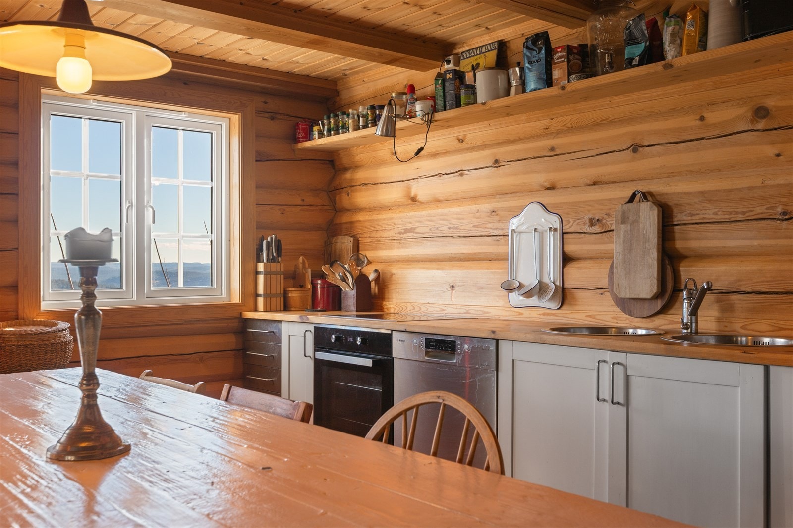 Lyst og romslig kjøkken med kjøkkeninnredning bestående av underskap med heltre benkeplate. Galleribilde