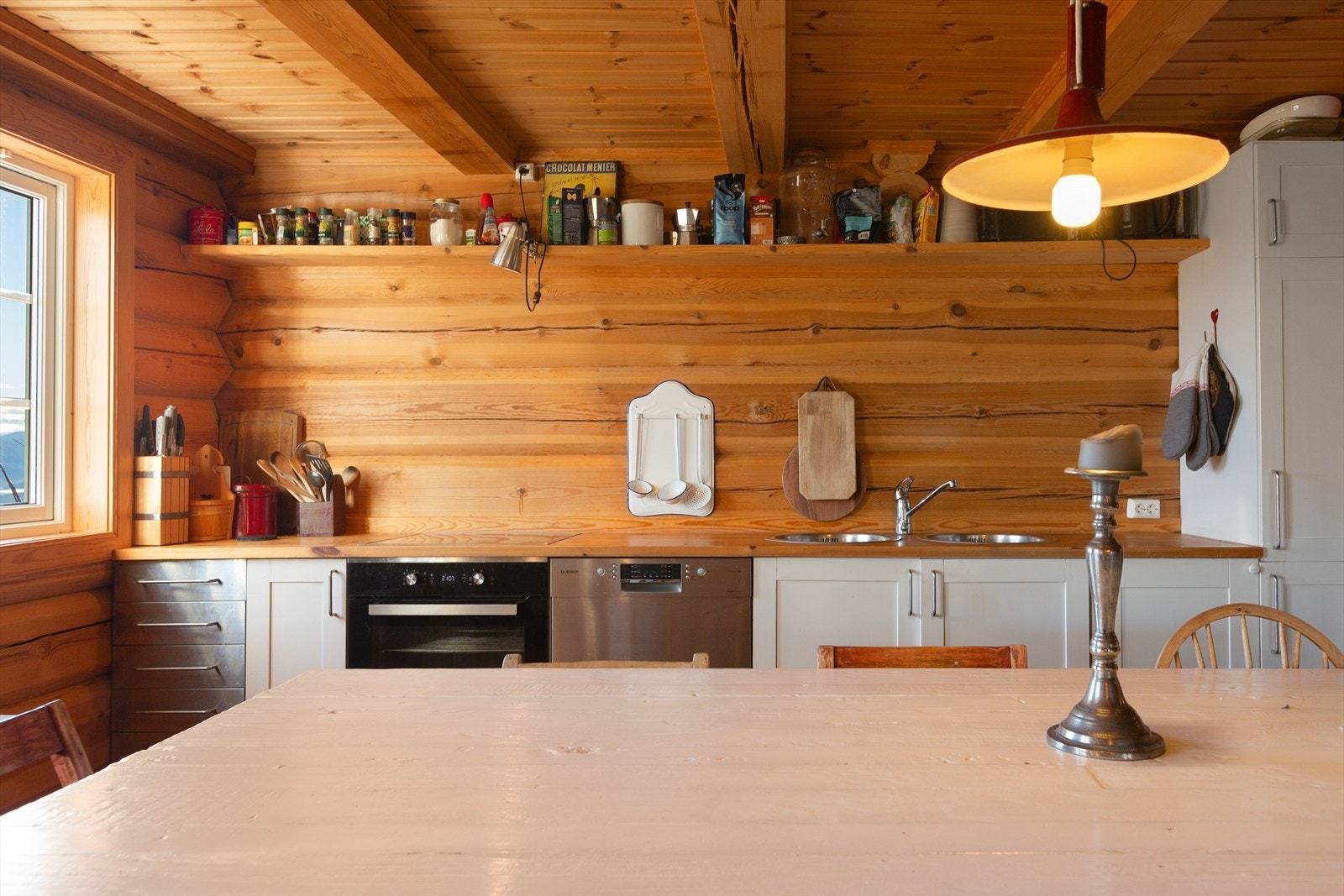 Det er bra med oppbevaringsplass i skap og skuffer, samt plassbygd hylle som går over kjøkkenbenken. Integrerte hvitevarer som komfyr, platetopp, oppvaskmaskin og kjøle-/fryseskap. Galleribilde