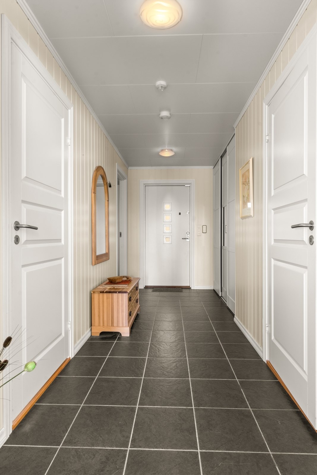 Her er det flislagt gulv med varme, inngang til to av soverommene samt badet. Galleribilde