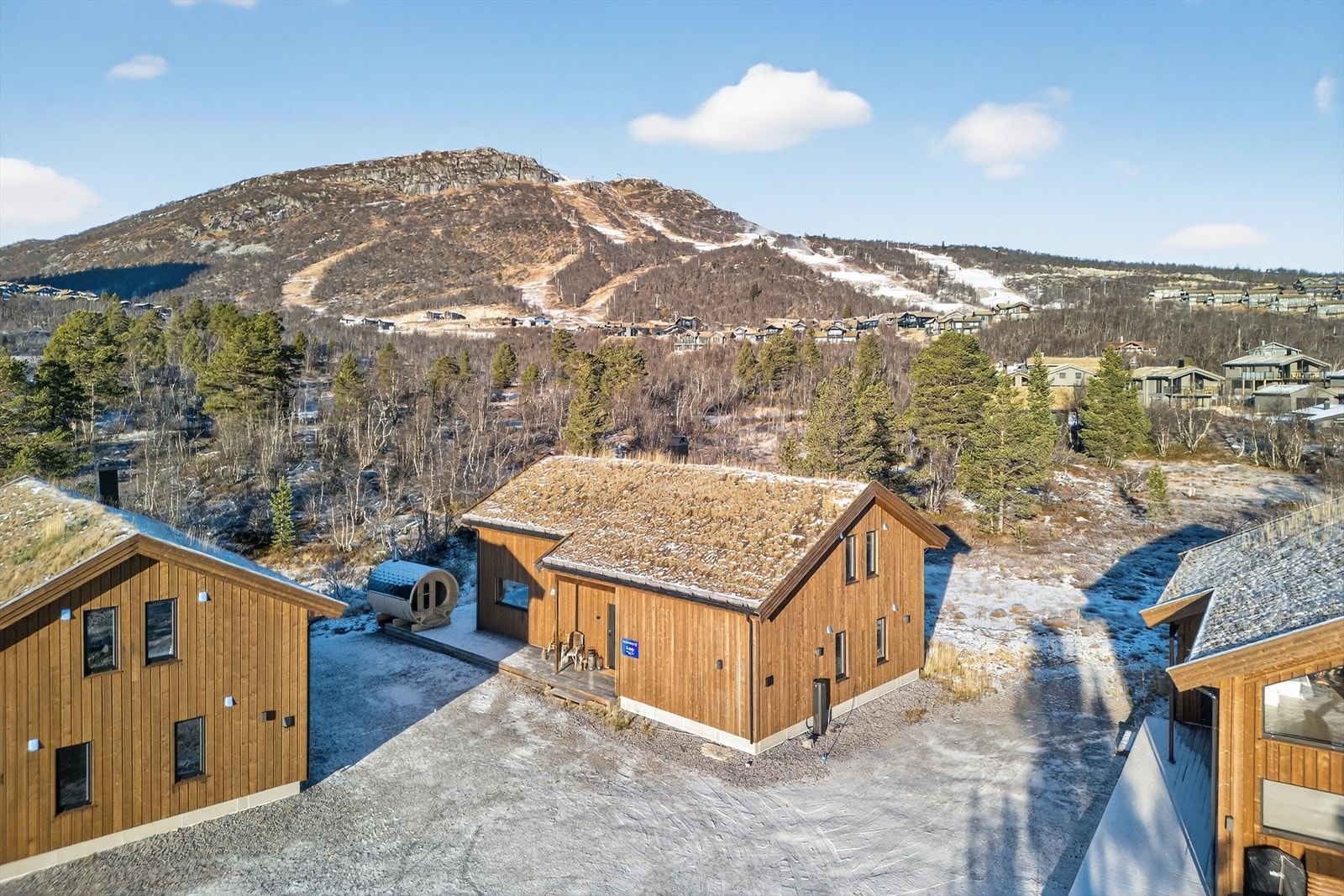 Parkering like ved inngang og med ladepunkt for el-bil på hytteveggen Galleribilde