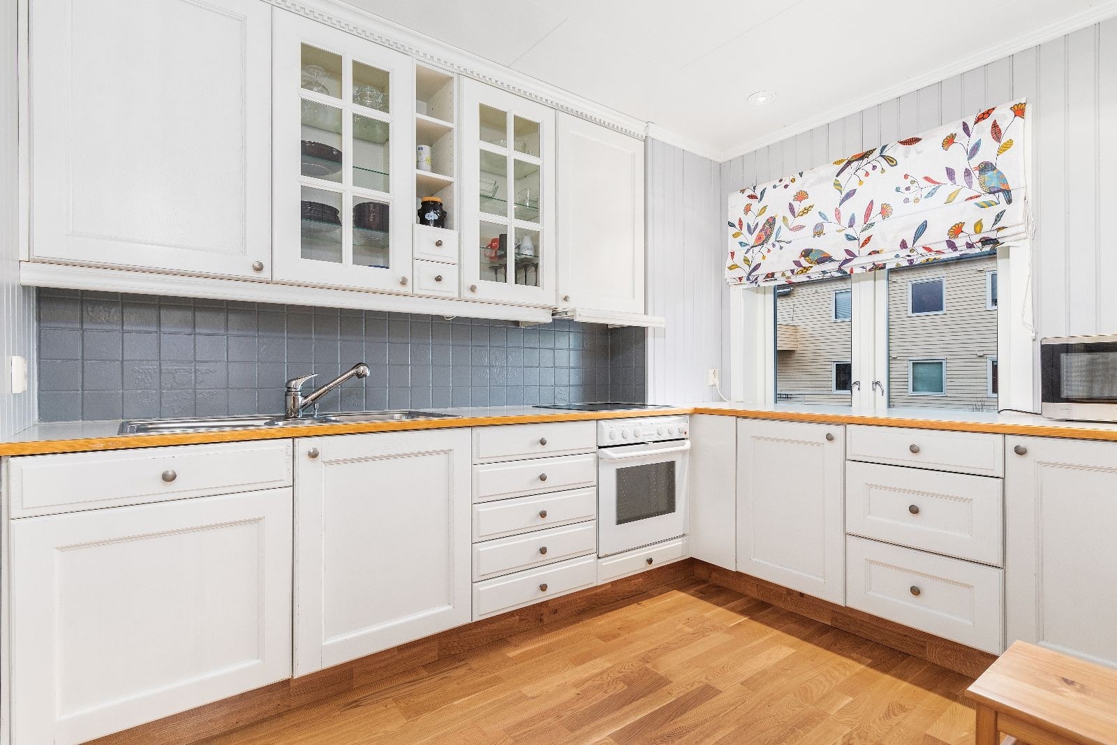 Kjøkkenet har godt med skap og benkeplass Galleribilde