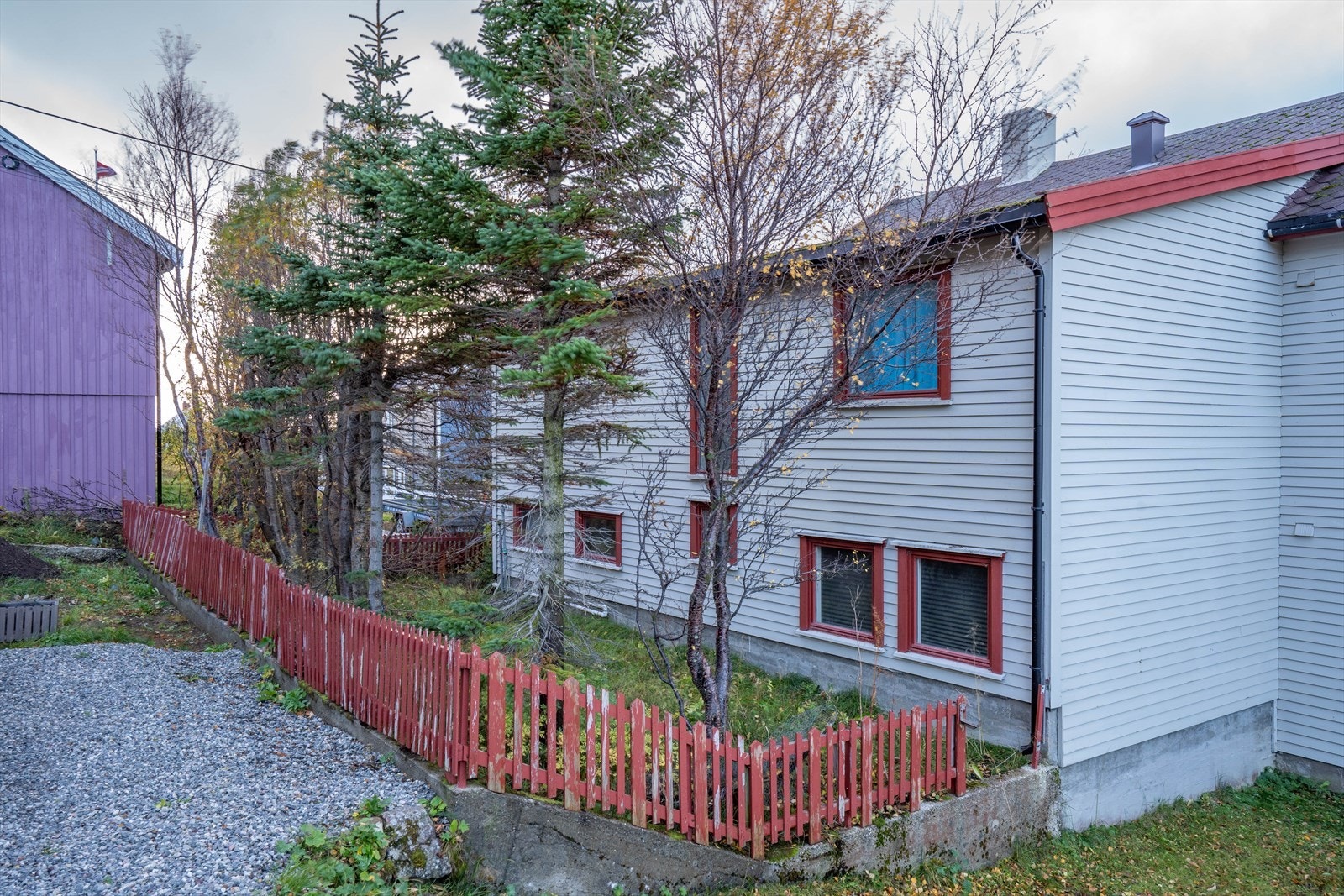 Sjarmerende bolig med rødt stakittgjerde og frodig hage. Rolig nabolag med gode solforhold. Galleribilde