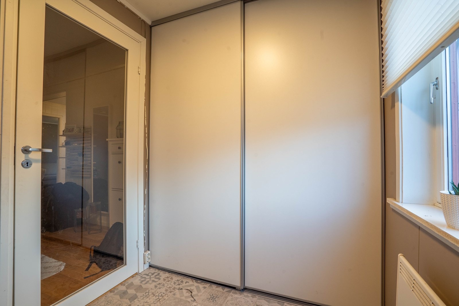 Vindfang med skyvedørsgardrobe samt dør inn til hall. Galleribilde