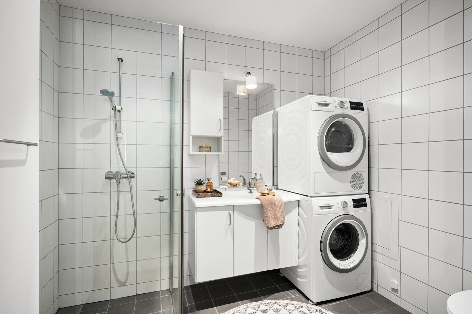 Tidløst bad fra 2007 med varmekabler, servantinnredning og dusjhjørne med foldedører av glass. Galleribilde