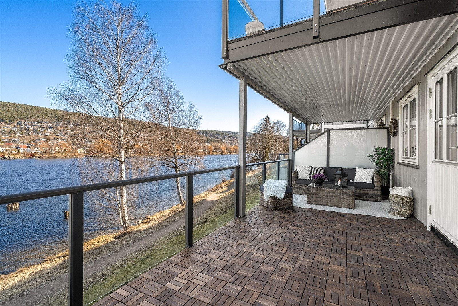 Romslig og usjenert terrasse på ca. 20 kvm med moderne glassrekkverk og levegg som skjermer for innsyn. Nordøstvendt beliggenhet gir både morgen- og kveldssol, og en flott utsikt over elven Galleribilde