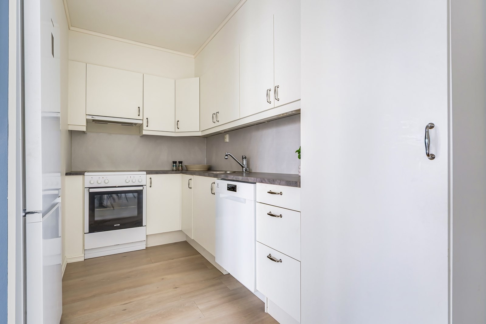Kjøkkeninnredningen fra Norema består av over- og underskap med slette fronter og benkeplater i laminat med nedfelt oppvaskkum i rustfritt stål og ett-greps blandebatteri. Galleribilde