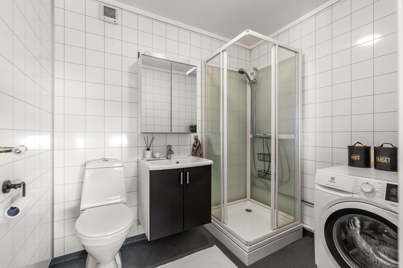 Badet ble pusset opp i 2008, og fremstår som velholdt, praktisk og pent. Her er det hvite våtromsplater i flisimitasjon på veggene og grått belegg på gulv med gulvvarme. Galleribilde