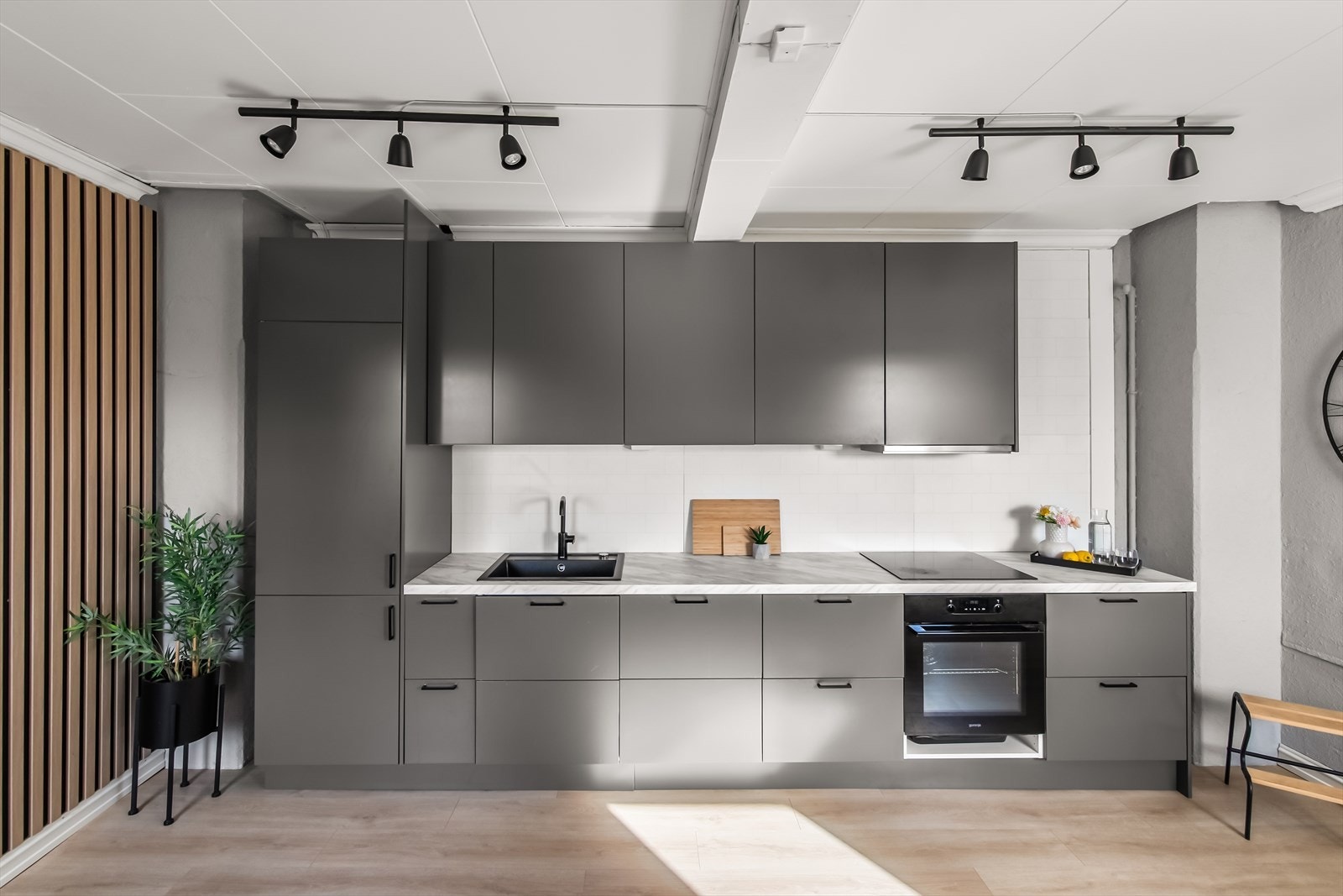 Innredningen fra Epoq har grå, glatte fronter og lys lamimatbenkeplate i marmor-look med nedfelt, sort oppvaskkum. Galleribilde