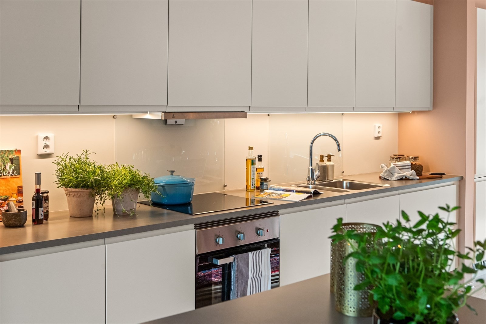 Integrerte hvitevarer inkluderer doble kjøl-/fryseskap, koketopp, komfyr og oppvaskmaskin. Galleribilde