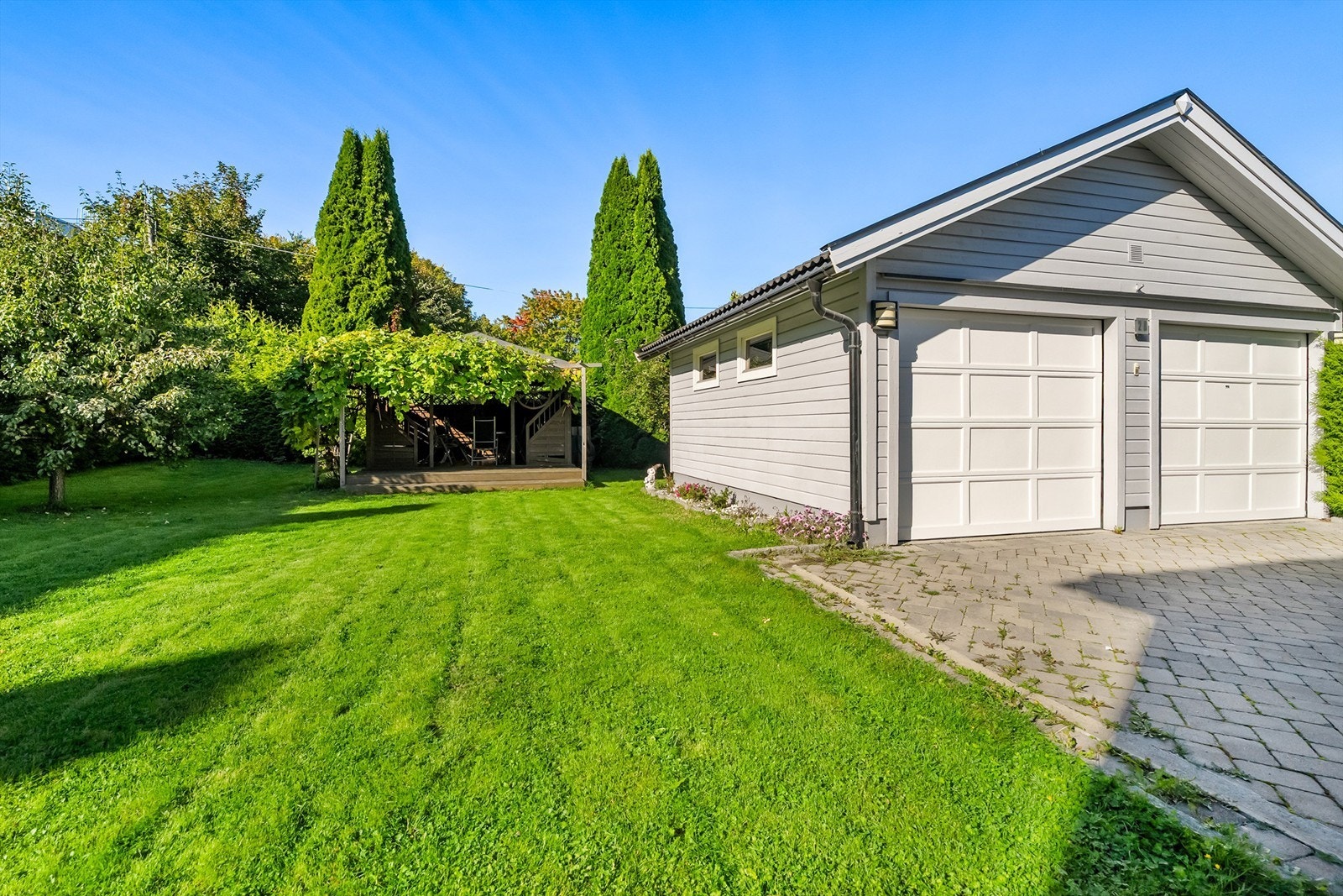 Solrik tomt med hage, garasje og steinlagt gårdsplass Galleribilde