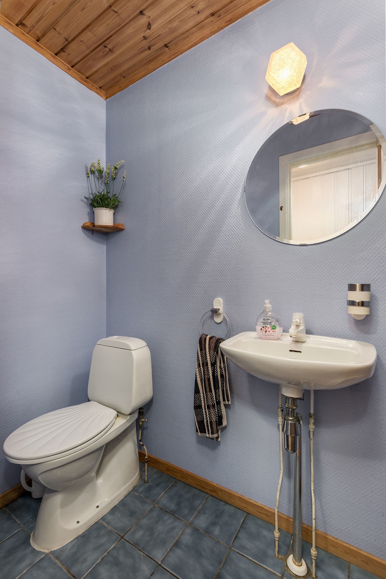 Toalettrom i kjeller med gulvstående toalett og servant. Galleribilde