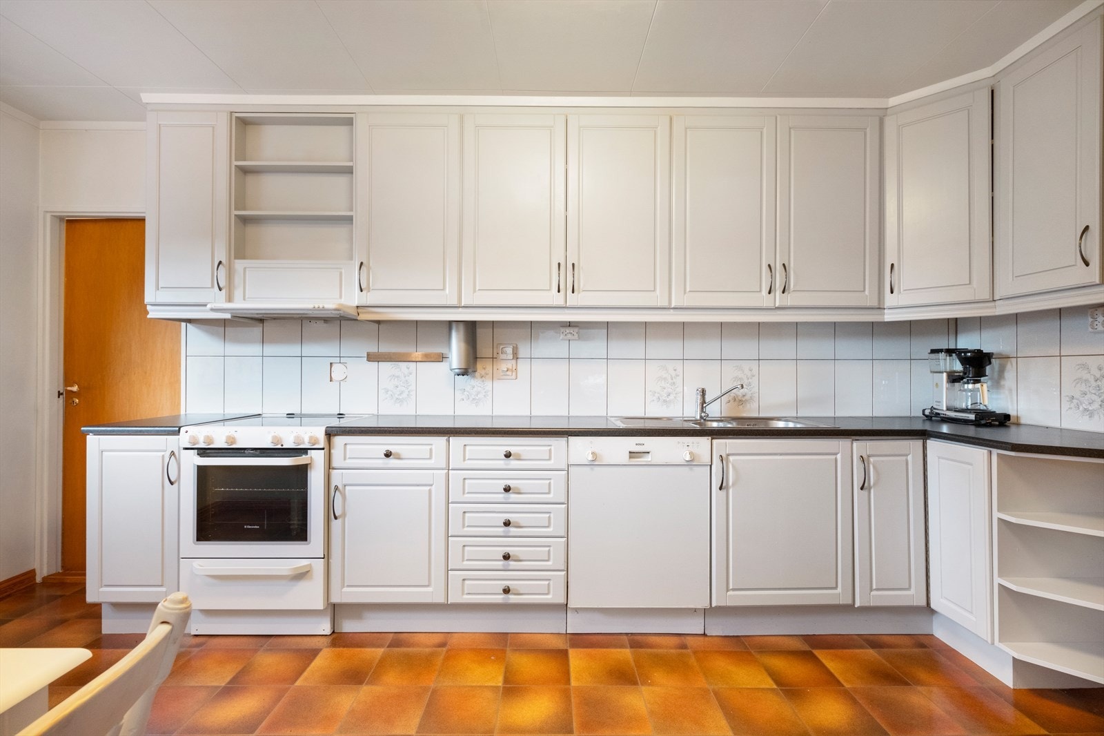 Kjøkkenet har innredning med profilerte hvite fronter Galleribilde