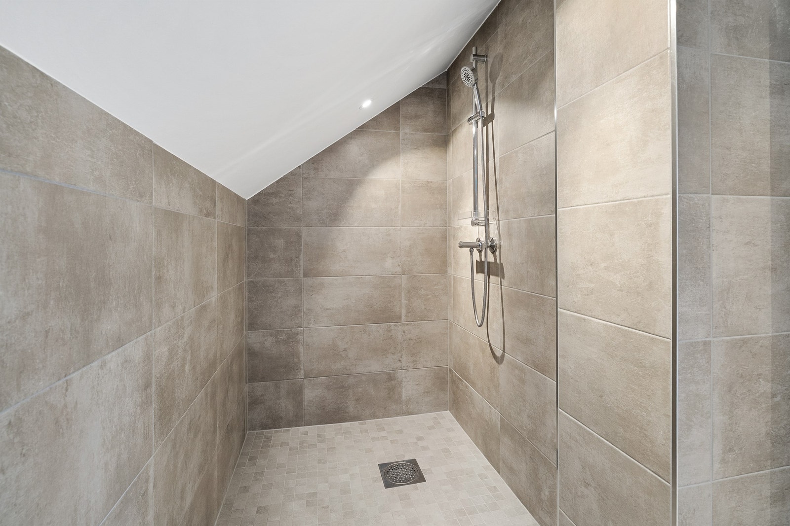 Fliser på gulv, fliser på vegger og malte slette flater i himling med downlights Galleribilde