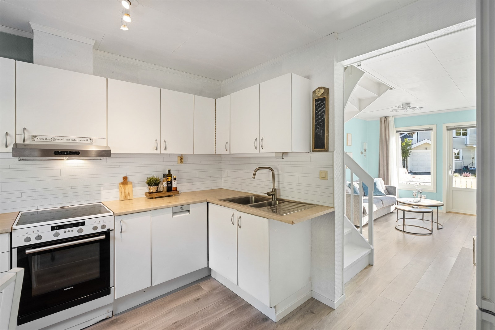 Kjøkkenet er utstyrt med komfyr med platetopp, ventilator i overskap, oppvaskmaskin under benkeplate og kjøleskap med fryserdel i nisje Galleribilde