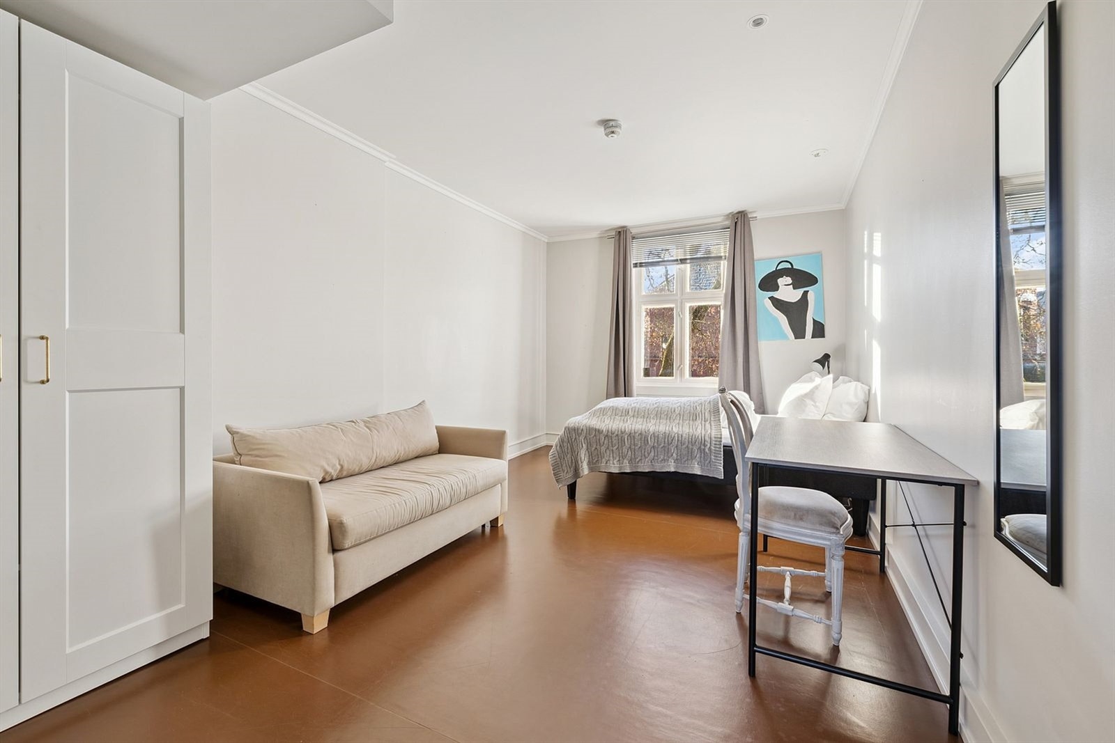 Lyst og stort soverom med seng, garderobeskap og sofa. Galleribilde