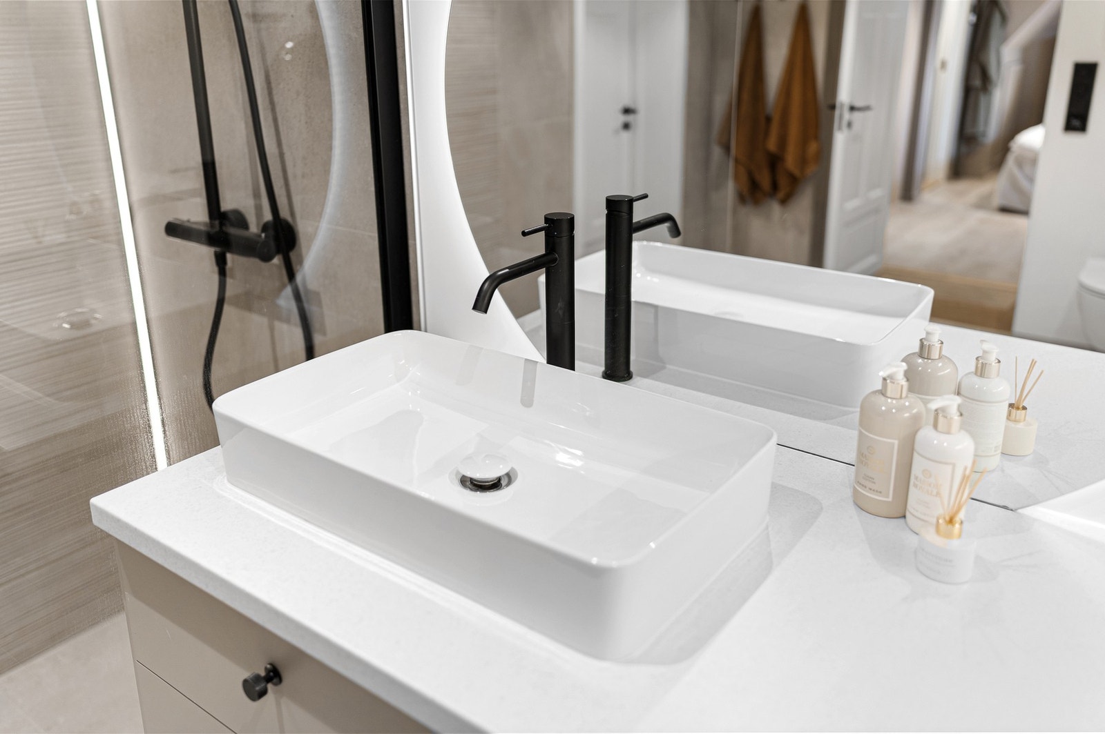 Flotte detaljer på badet, som det gjennomgående sorte på knotter/håndtak, armatur og feste i dusjveggen. Stort speil som bidrar til at rommet føles desto større. Galleribilde