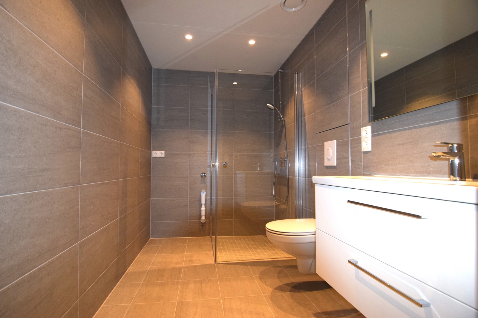 Bad med dusjhjørne og opplegg for vaskemaskin. Galleribilde