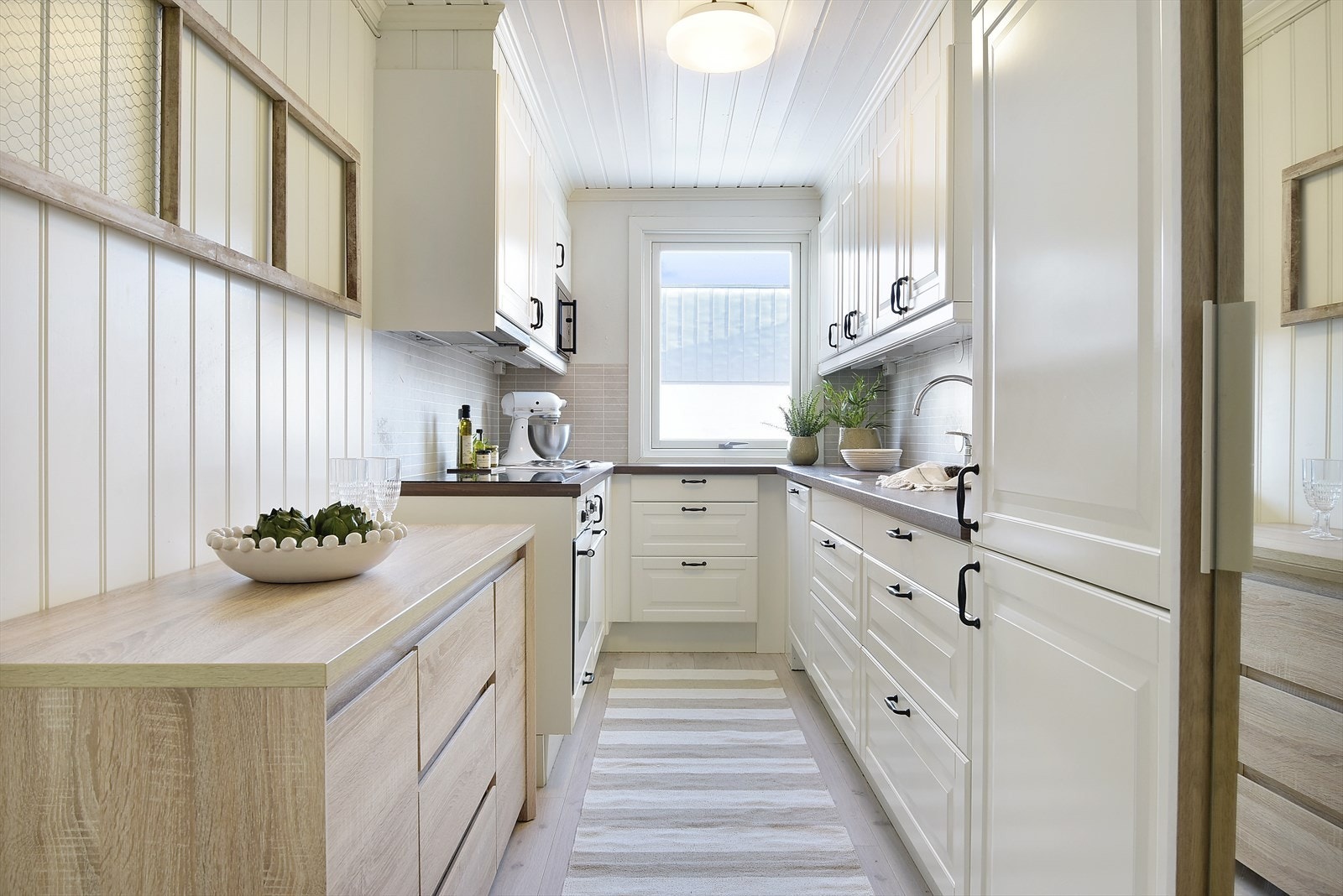 Pent kjøkken som har godt med skap- og benkeplass. Galleribilde