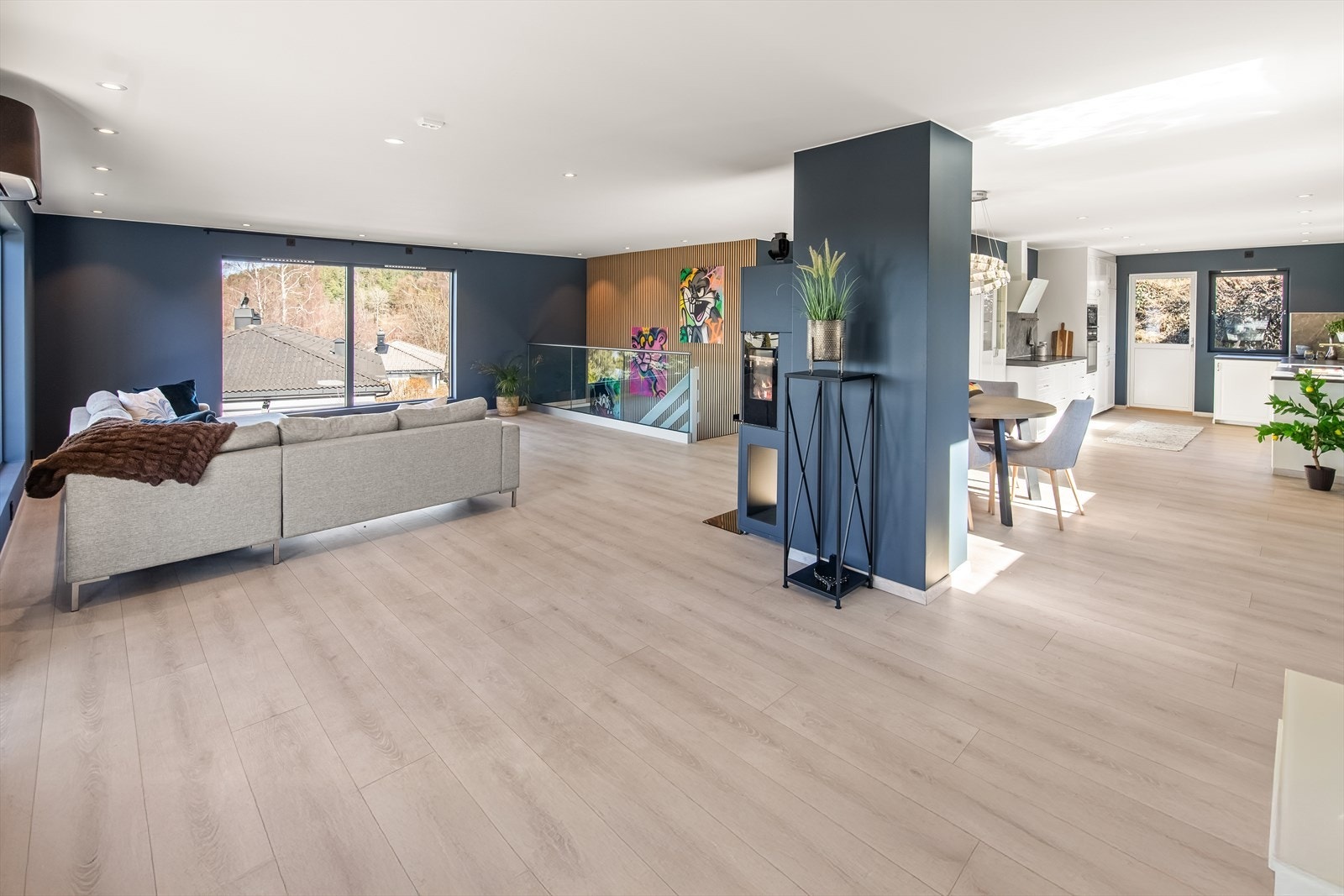 Samtidig finnes det godt med veggplass for møblering, og midt i rommet finner man et effektivt ildsted som skaper både varme og stemning. Galleribilde