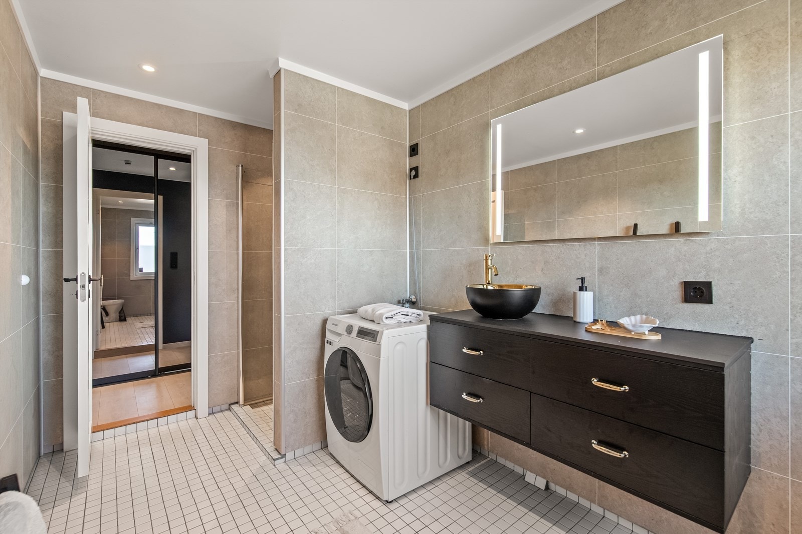 Baderommet er overflateoppusset i 2022 med nye veggflater, ny baderomsinnredning, samt dusjgarnityr og dusjdør. Det er overflater av fliser på gulv og baderomsplater på vegger og det er varmekabler i gulv. Galleribilde