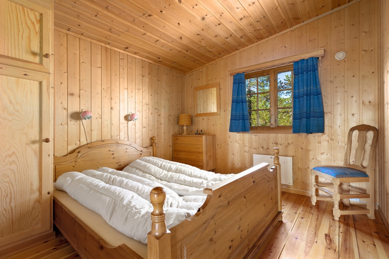 Hovedsoverommet har plass til en dobbeltseng og er innredet med nattbord fastsatt i veggen, samt et praktisk klesskap Galleribilde