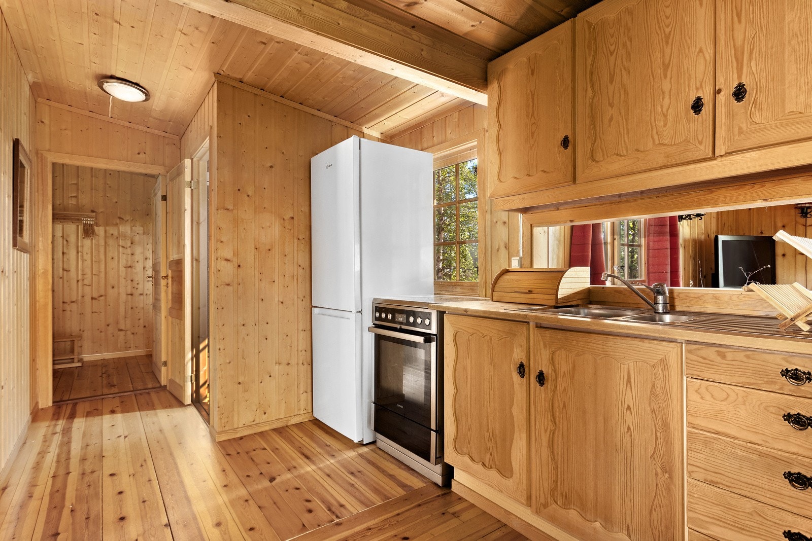 Kjøkkenet er lite og koselig, med en rustikk sjarm som fremheves av mursteinsveggen som skiller den fra spisestuen Galleribilde