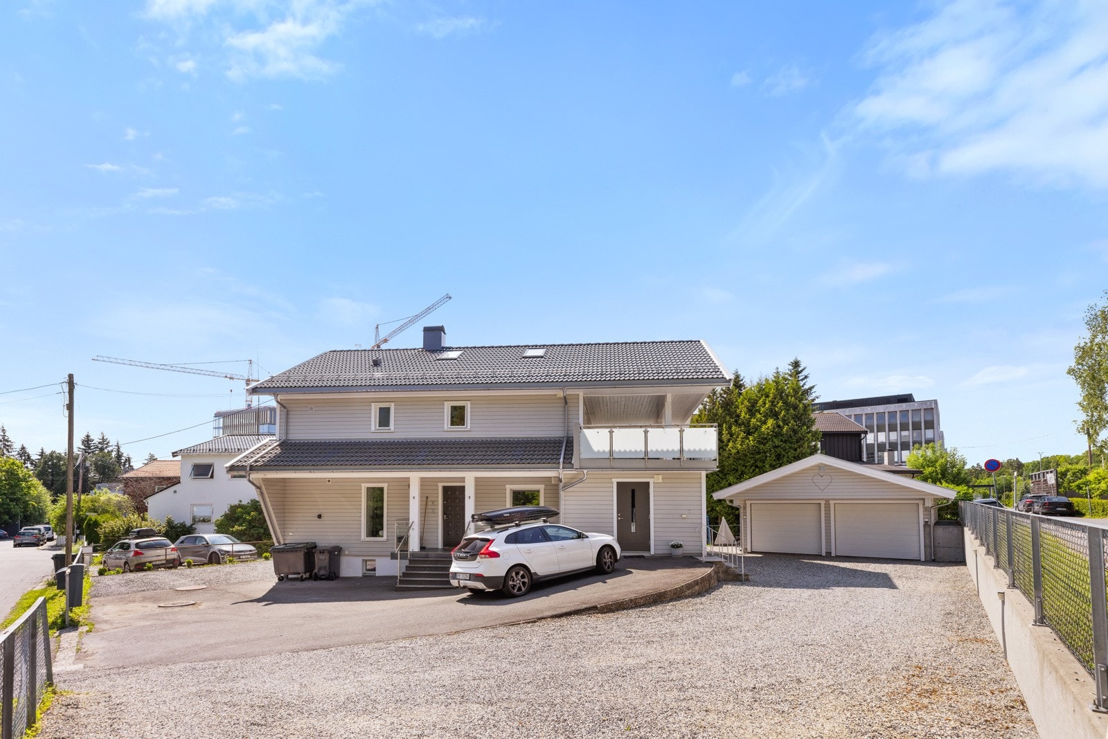 Tomten er åpen, med asfaltert adkomstvei og gruslagte partier med biloppstillingsplass. Galleribilde