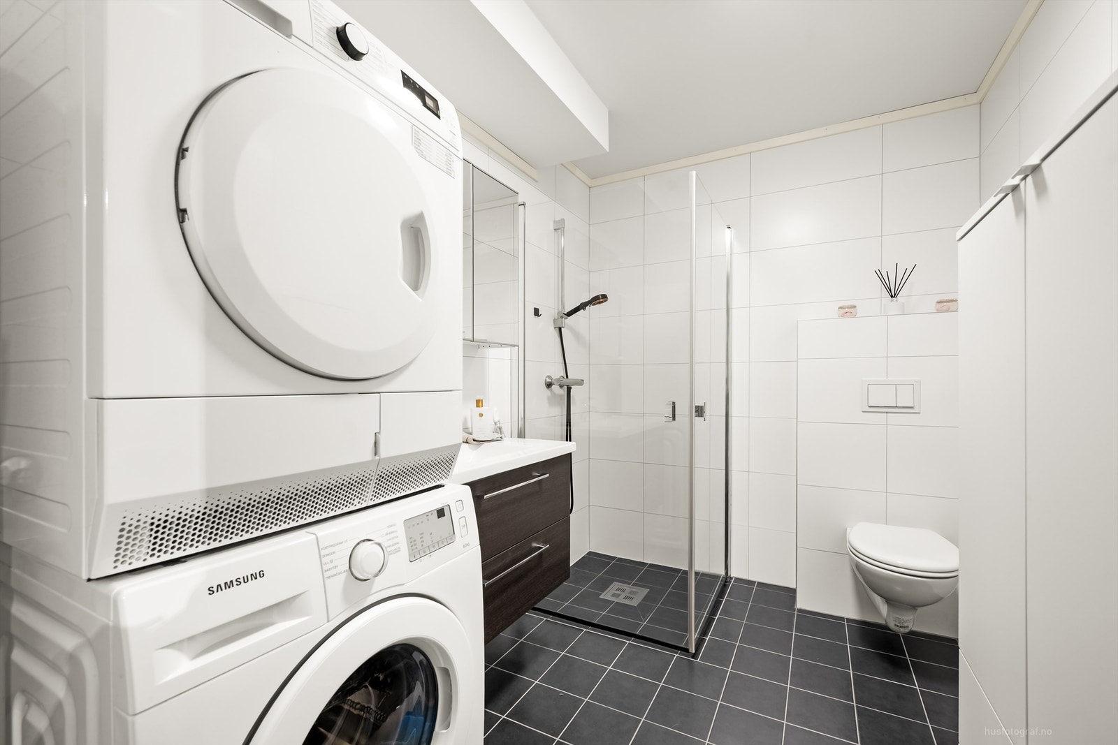 Badet har dusjhjørne med foldedører av glass Galleribilde